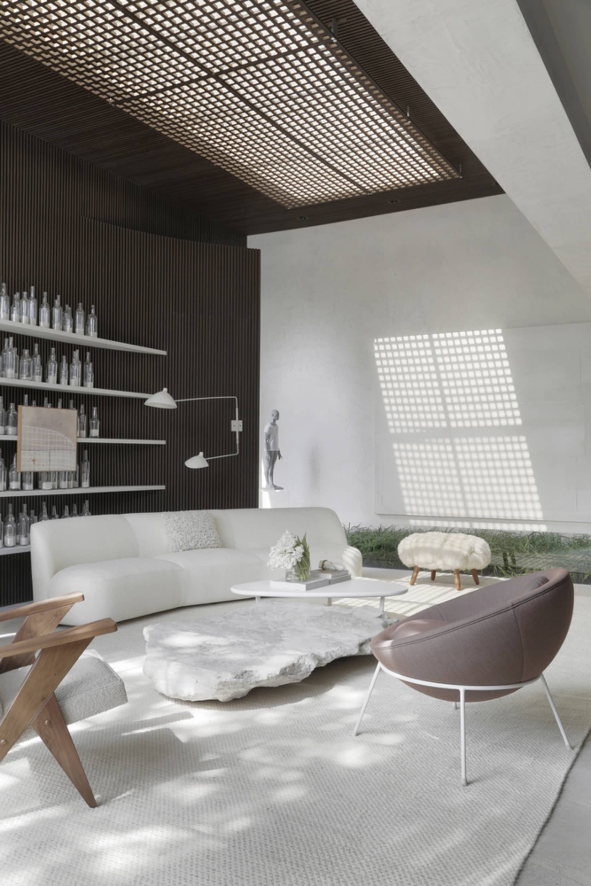 A modern living room featuring a white sofa, stone coffee table, and various lighting elements.