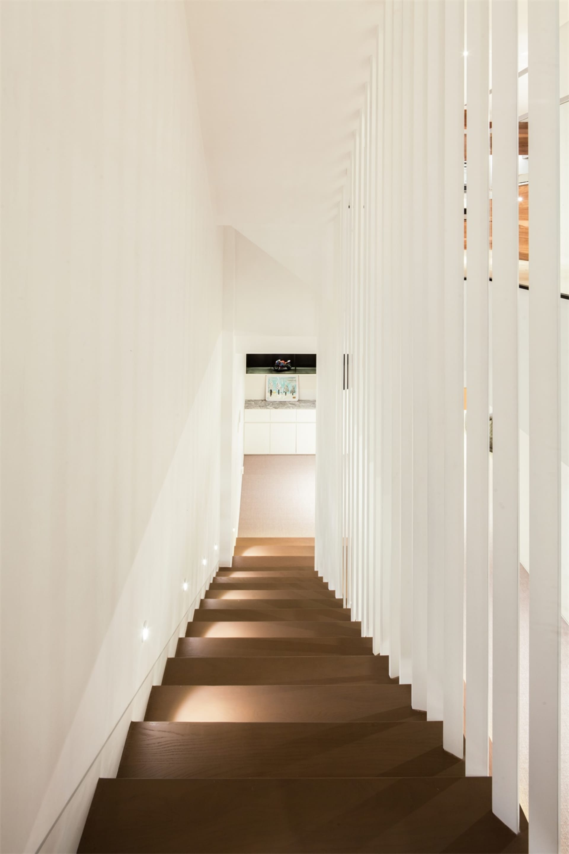 Modern minimalist staircase with lighting in a contemporary interior design setting.