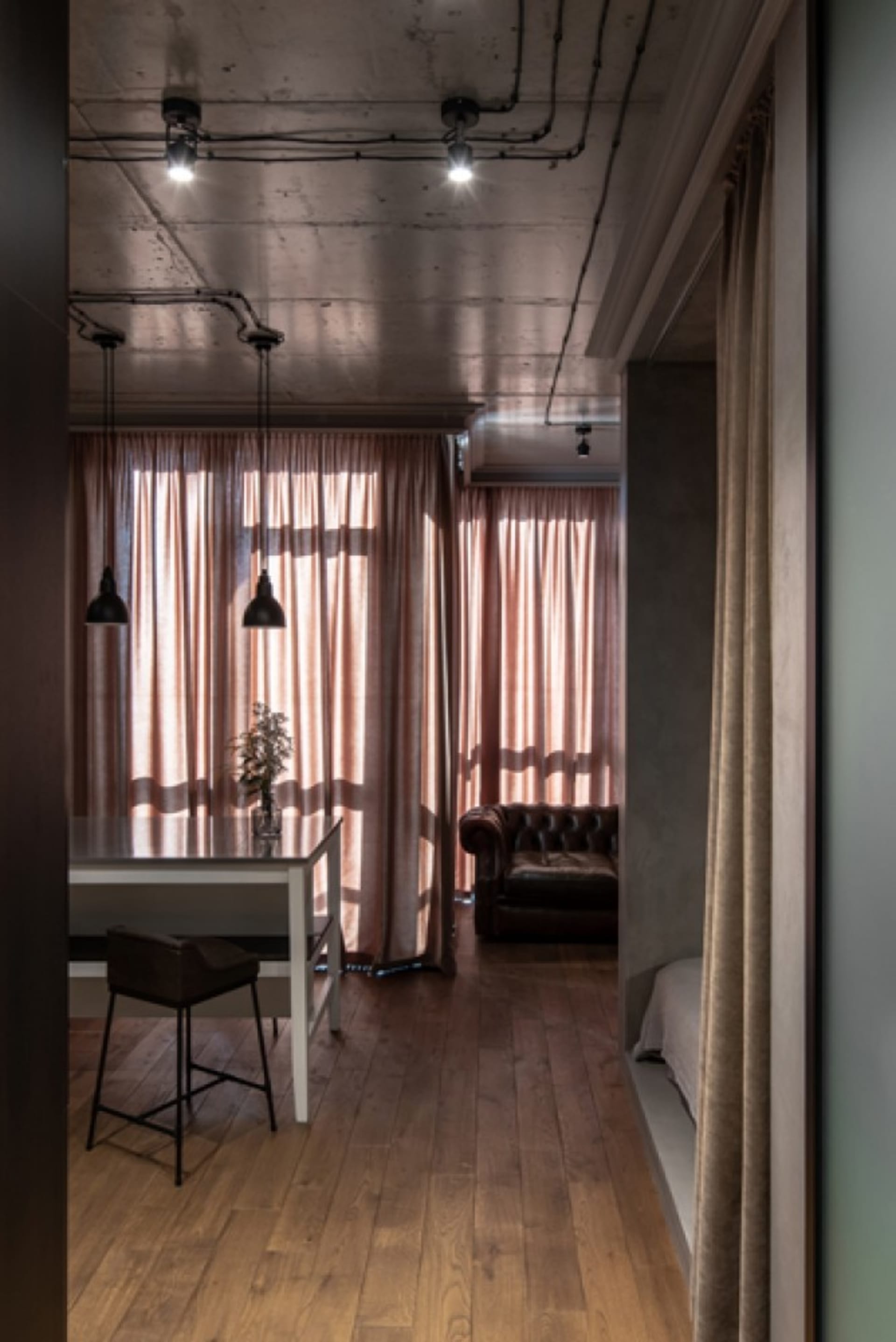 A residential interior featuring industrial-style decor with curtains and flooring.