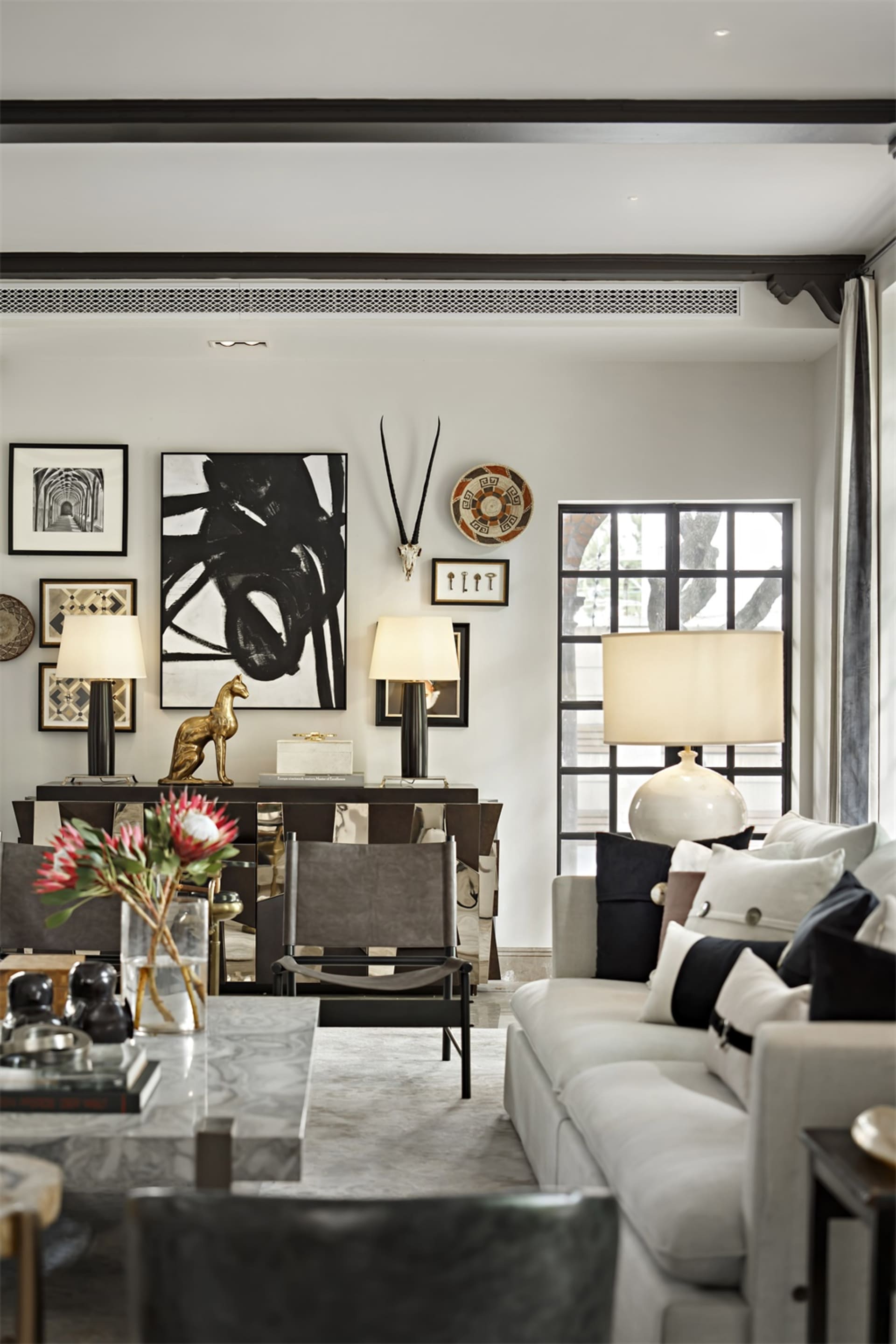 A minimalist living room with marble, leather, and glass materials.