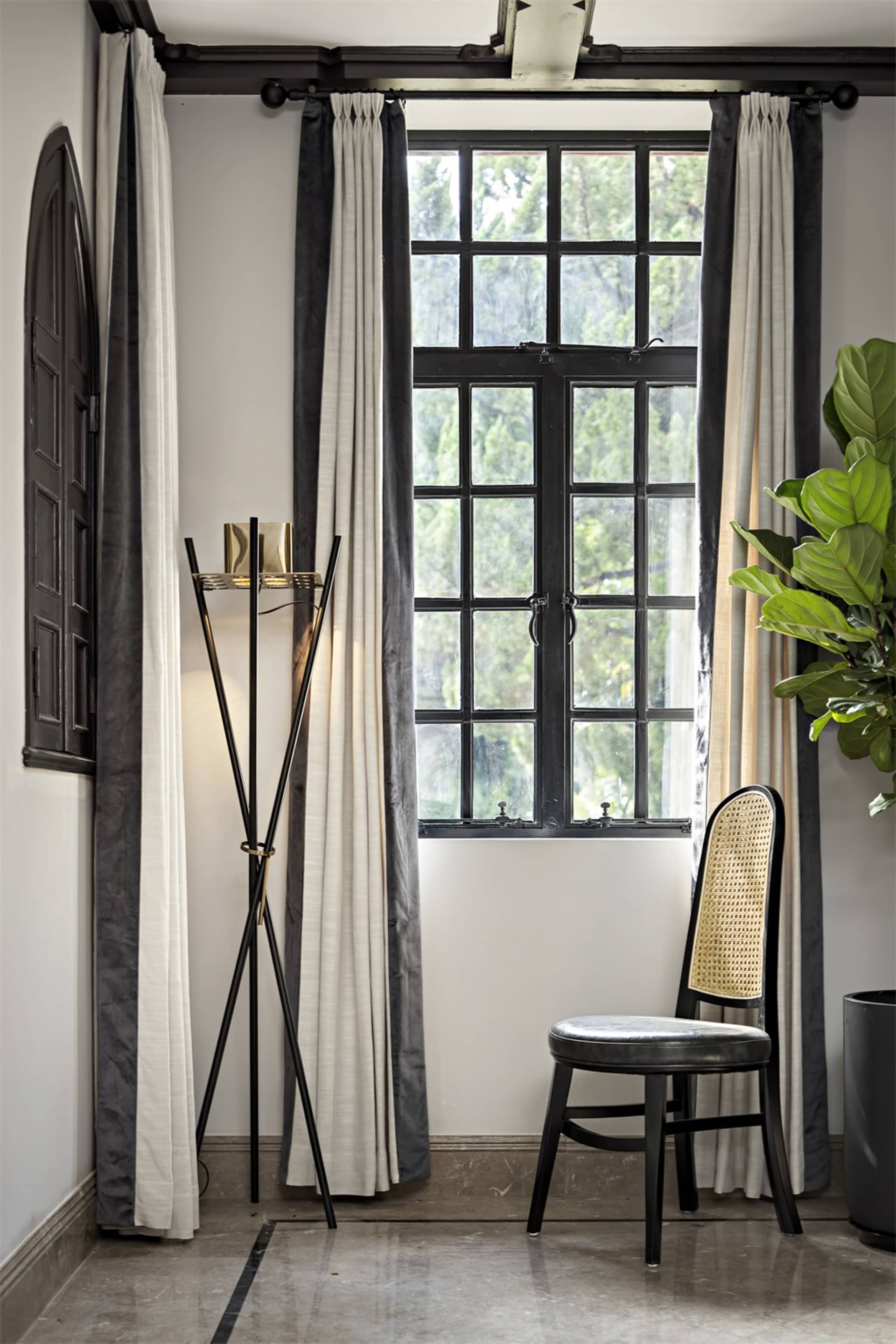 Modern living room featuring fabric curtains, glass window, and metal accents.