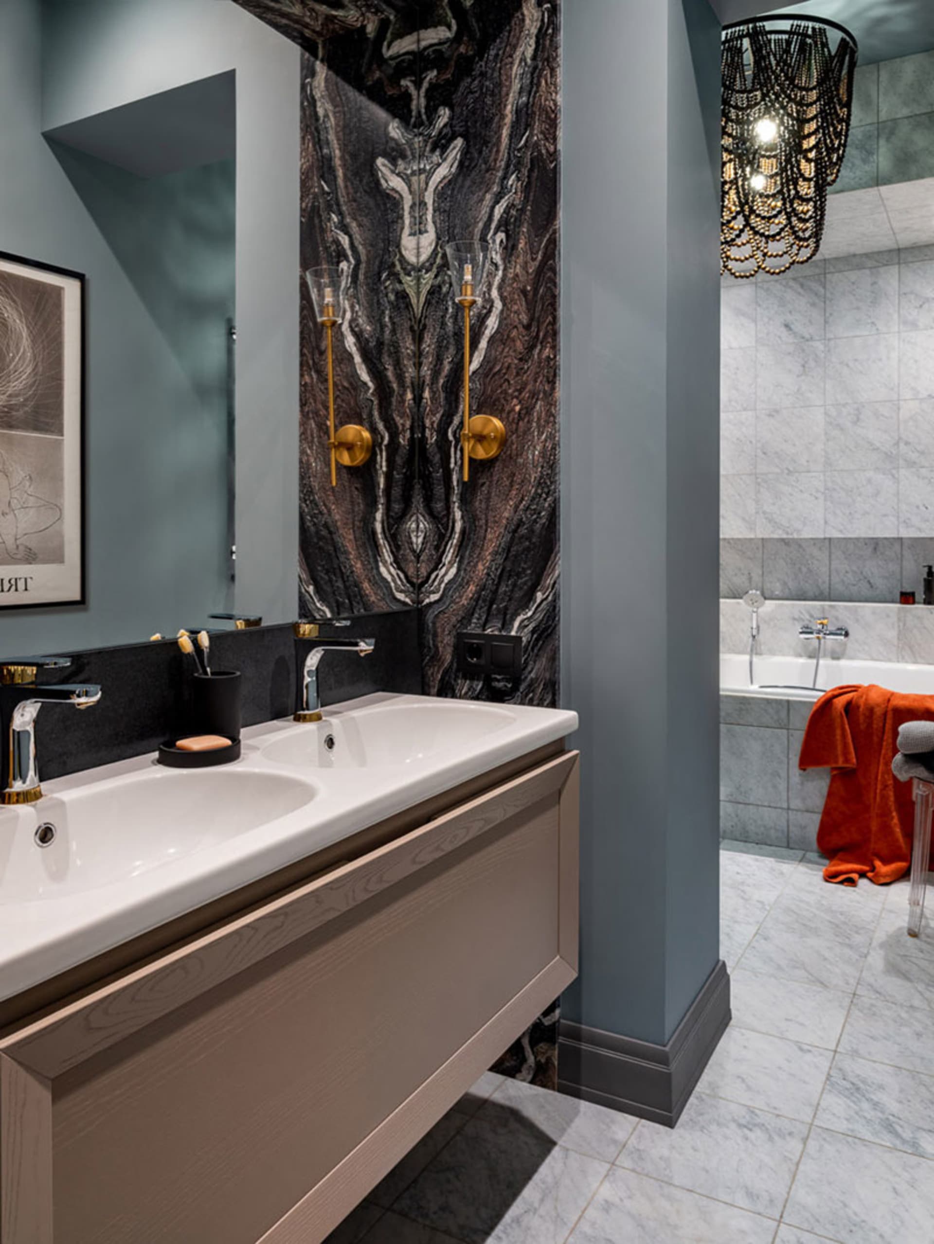 A modern bathroom with marble walls and beige wooden cabinets.