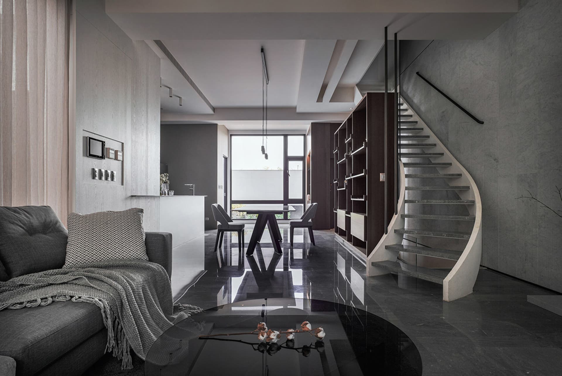 A stylish modern interior featuring a black concrete floor, metal accents, and a sleek furniture arrangement including a larg