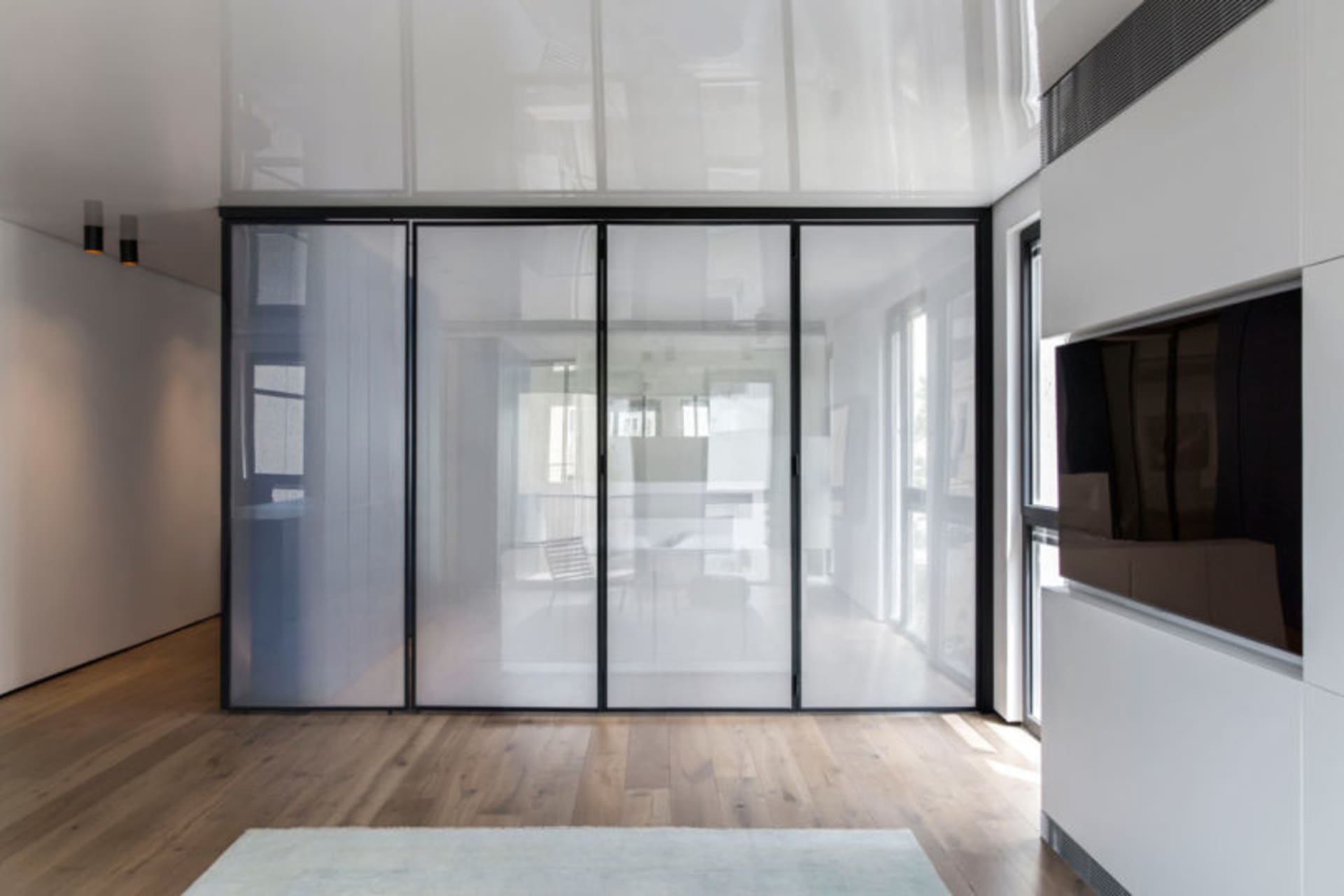 A modern minimalist room divider made of glass, featuring clean lines and a sleek design.