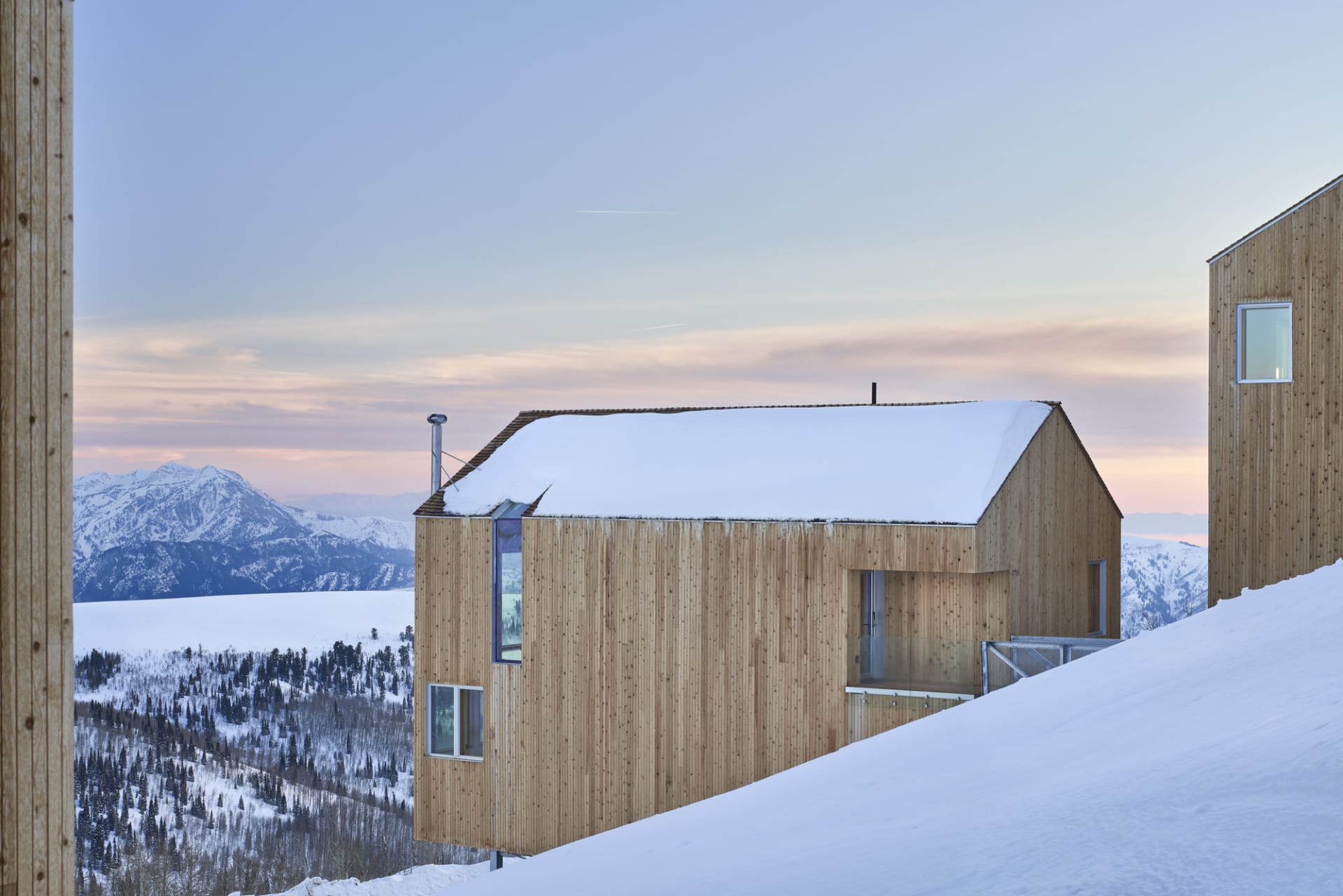Modern residential house covered in snow with wooden exterior during winter
