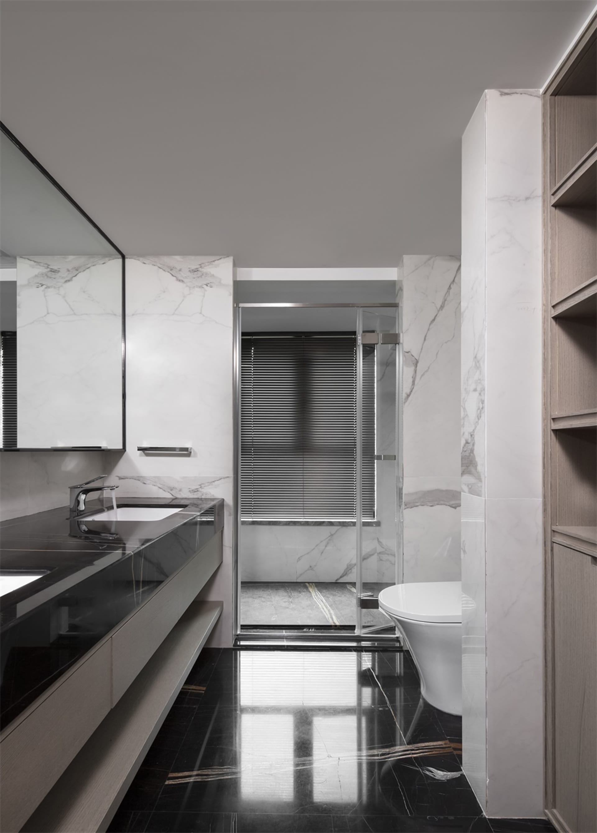 Modern bathroom with marble walls and black tile floor