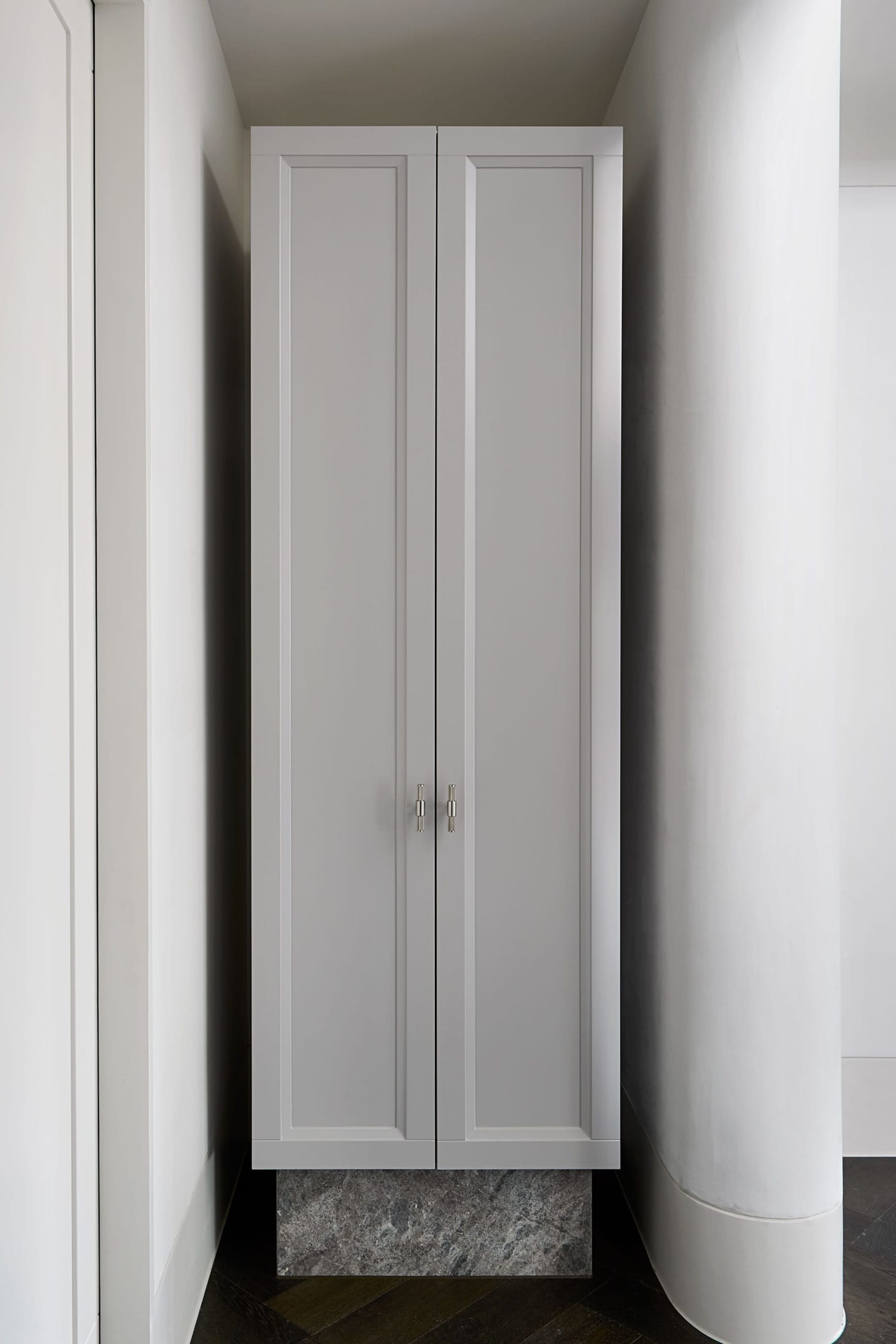 Modern interior design featuring a gray closet with concrete base, ideal for organizing clothing.