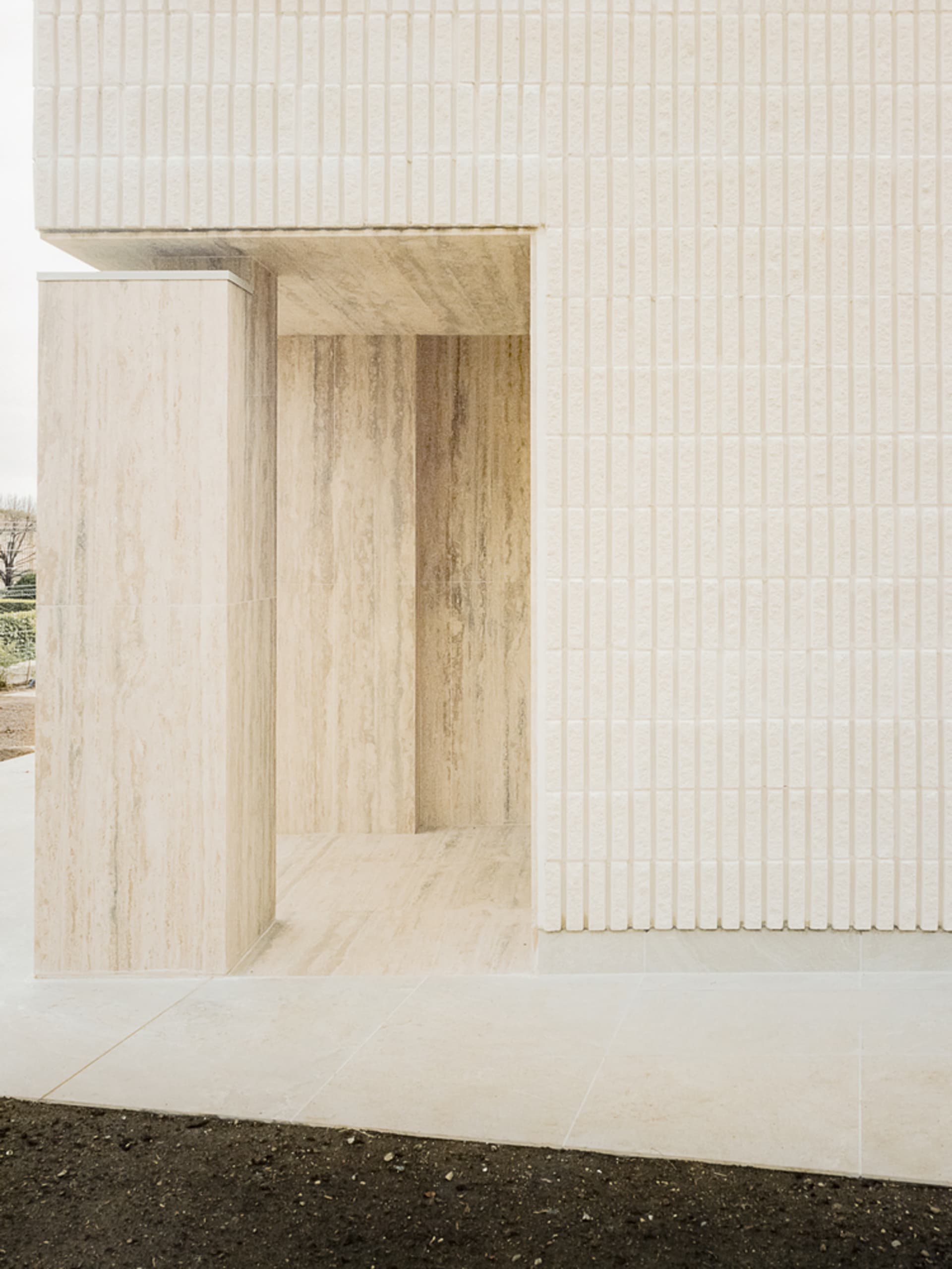 A minimalistic interior space with white marble walls and flooring.