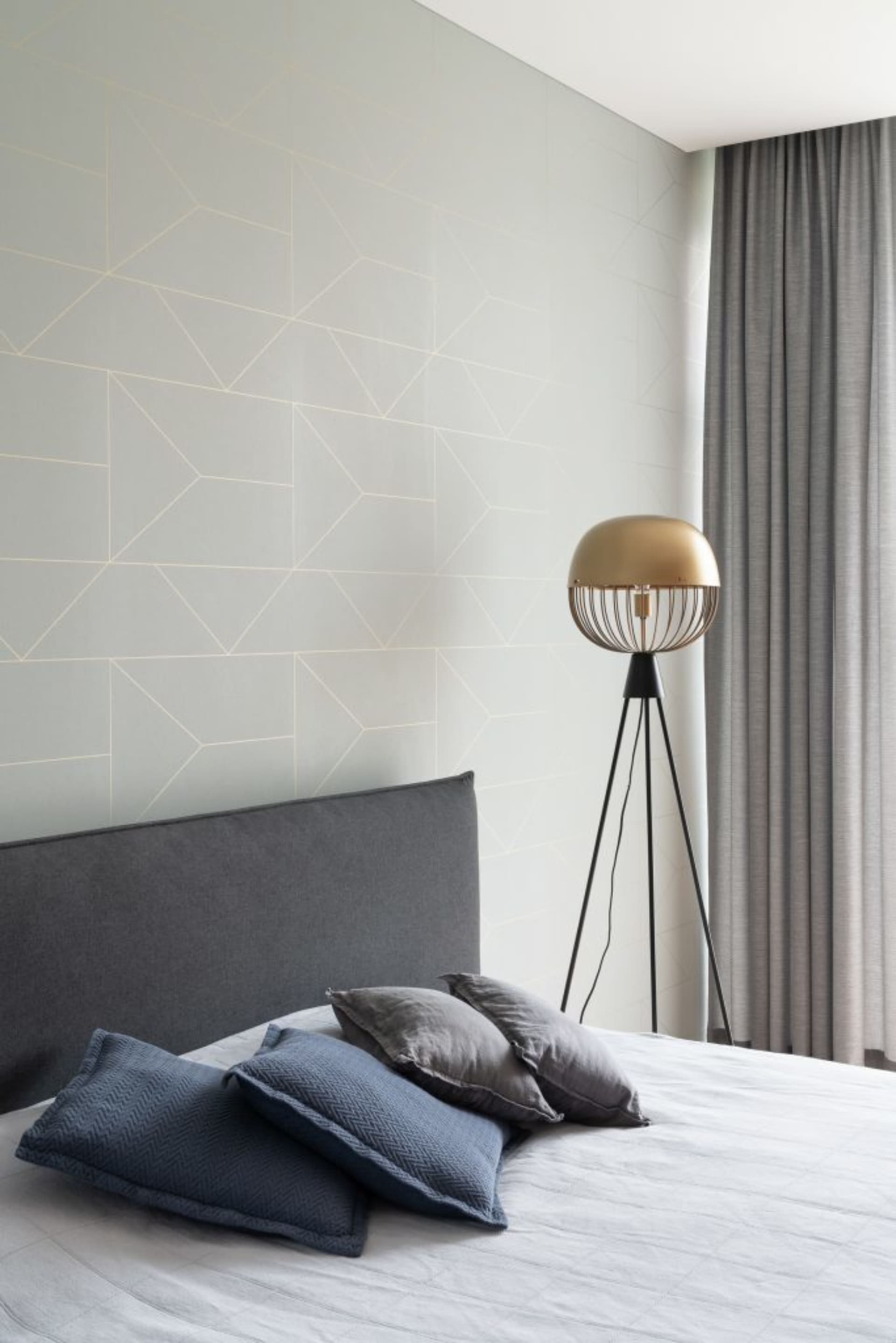 Gray fabric upholstered headboard and cotton bedding in a modern bedroom.