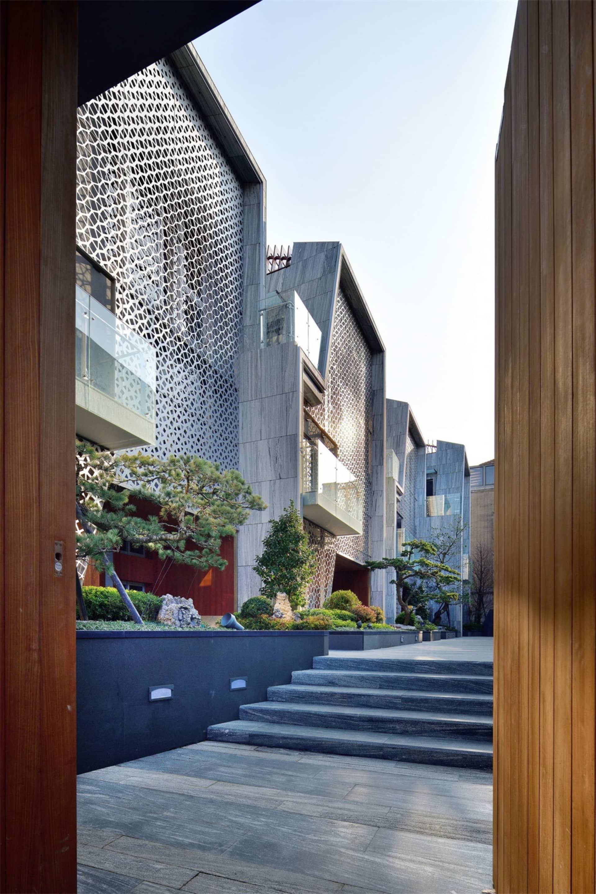 A modern building with metal and stone cladding situated on a cliffside.
