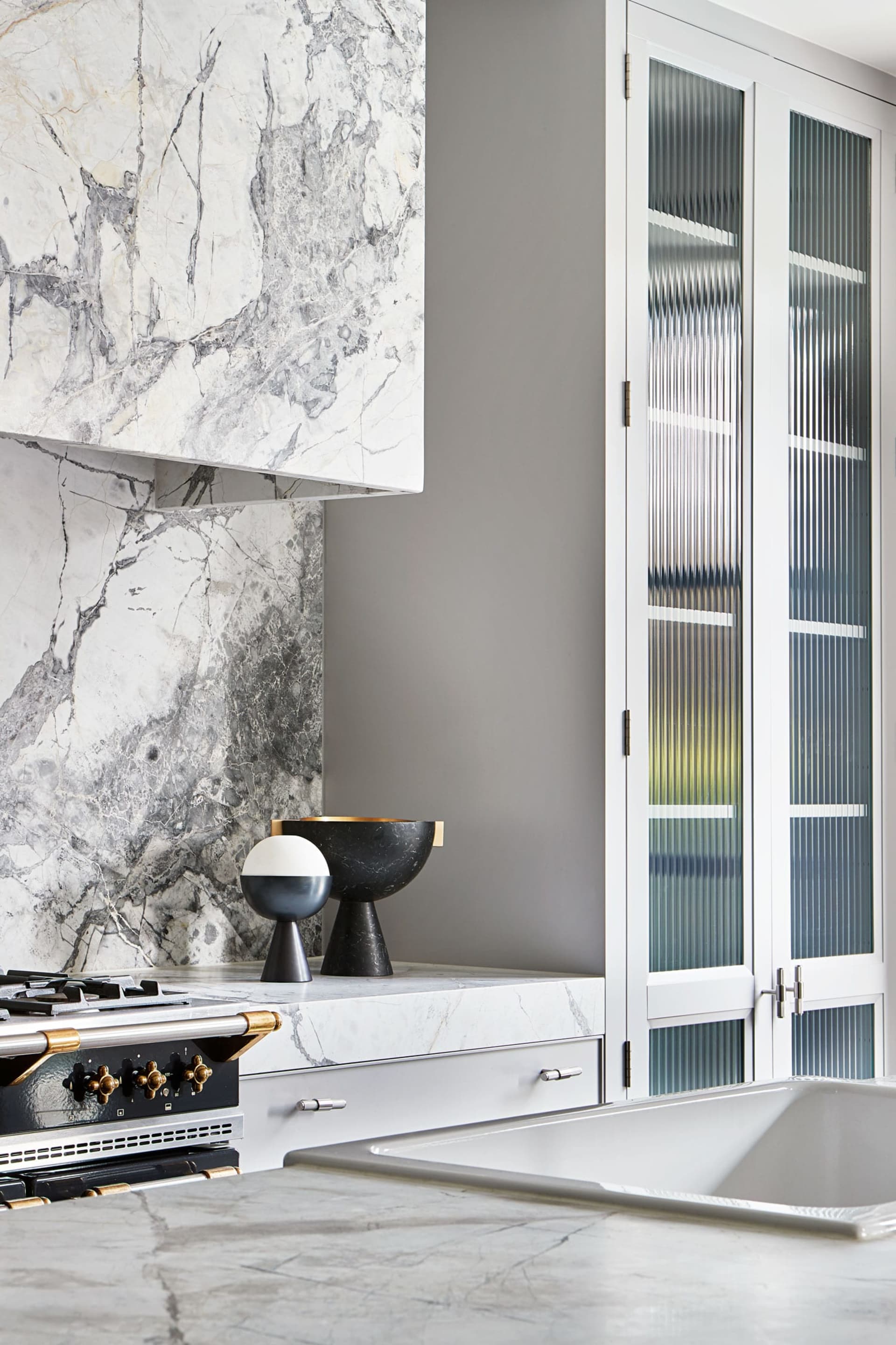 Luxurious residential kitchen featuring marble countertops and backsplash.