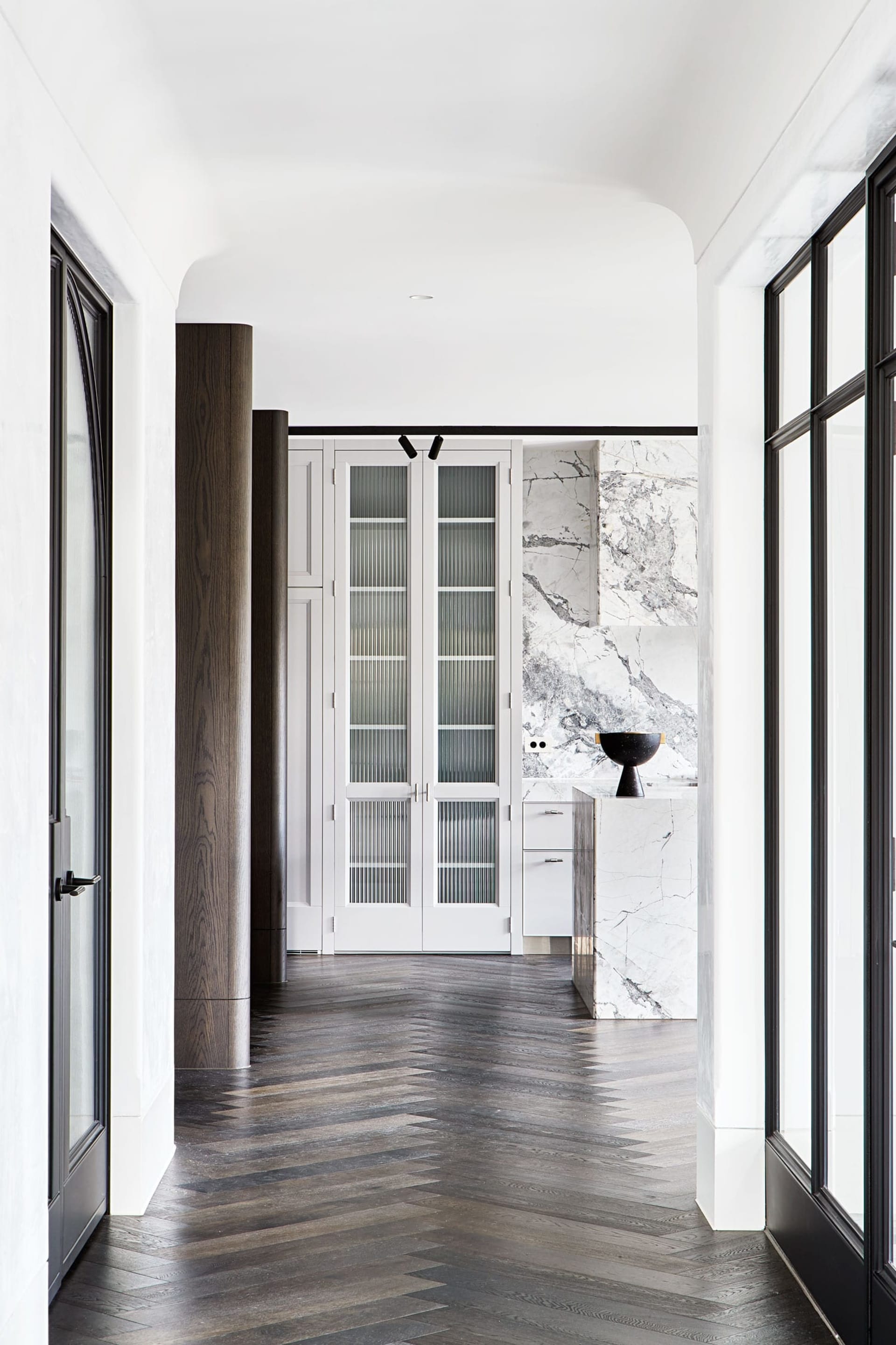 A modern interior with wooden and marble surfaces, and glass elements.