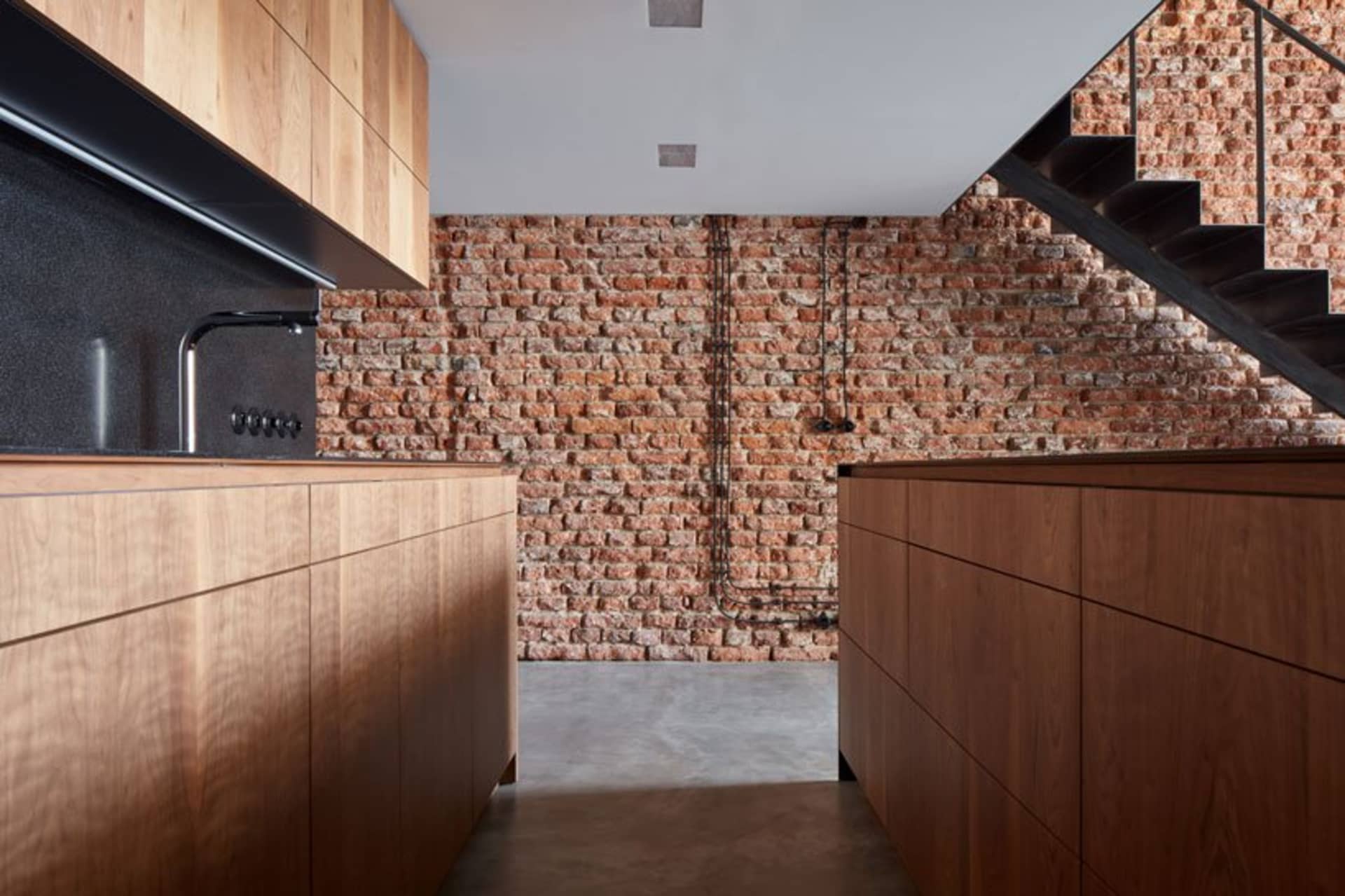 Industrial-style kitchen with reclaimed wood cabinets in a spacious, open-plan layout.