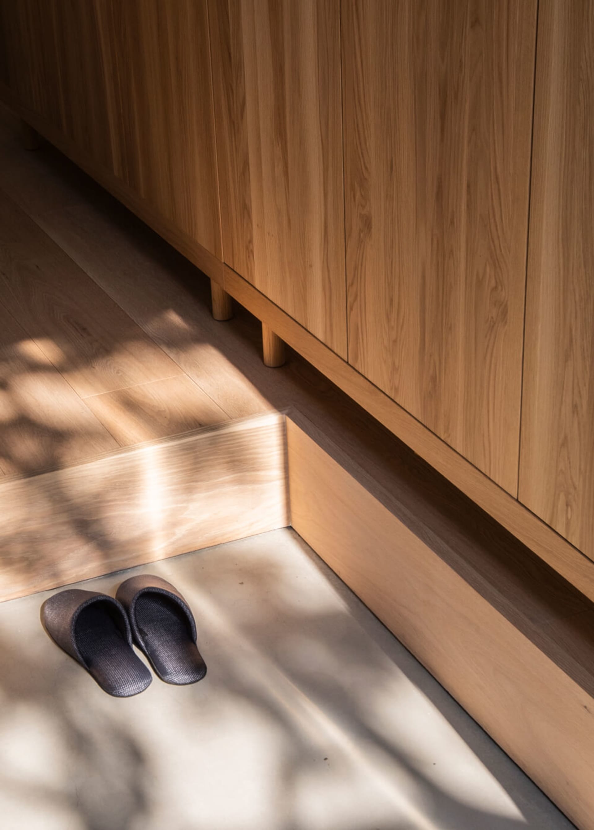 Wooden minimalist entryway with slippers on the floor.