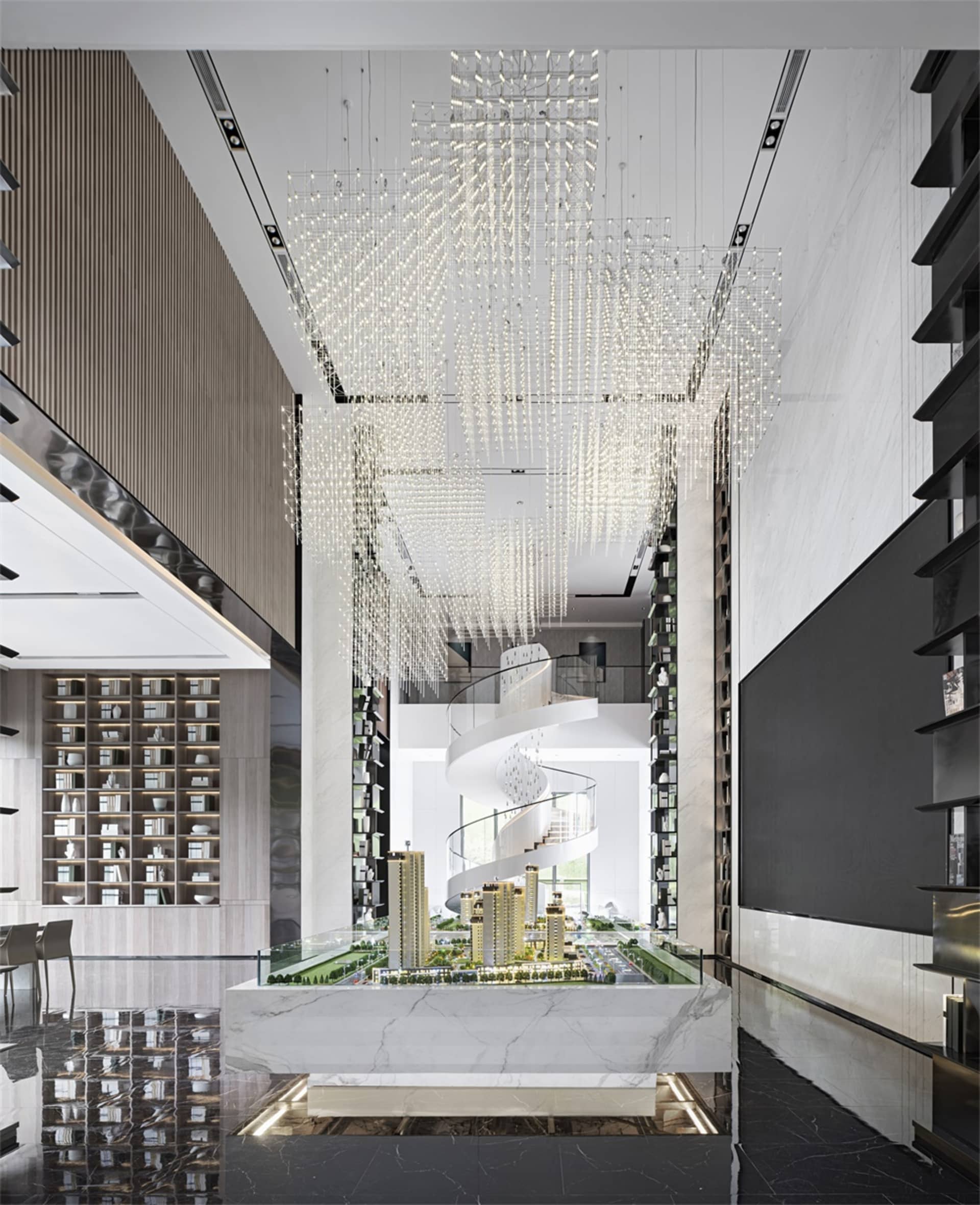 Modern lobby interior with glass chandeliers, marble accents, and metal spiral staircase.
