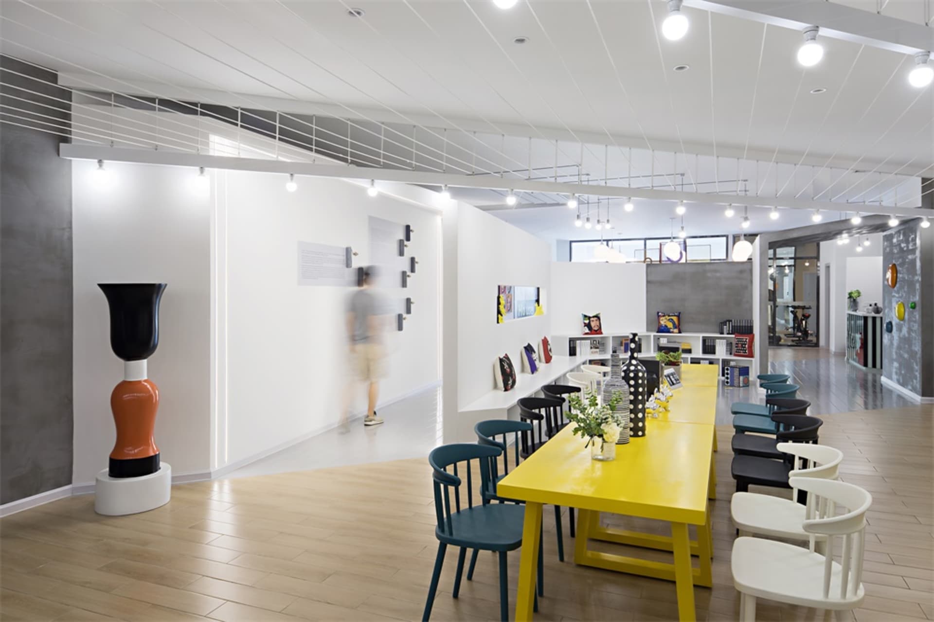 A modern office space with yellow tables and blue chairs.