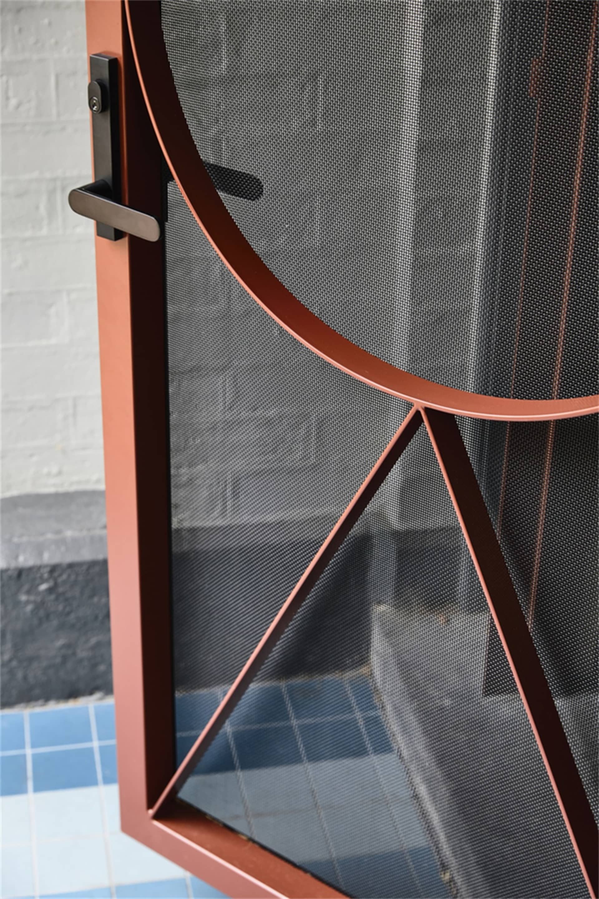 A detailed architectural image featuring a metal mesh-patterned door with a unique design.