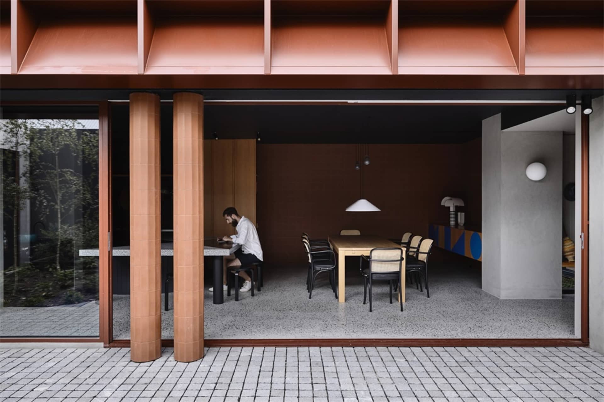A modern dining room featuring wood, concrete, and glass materials.
