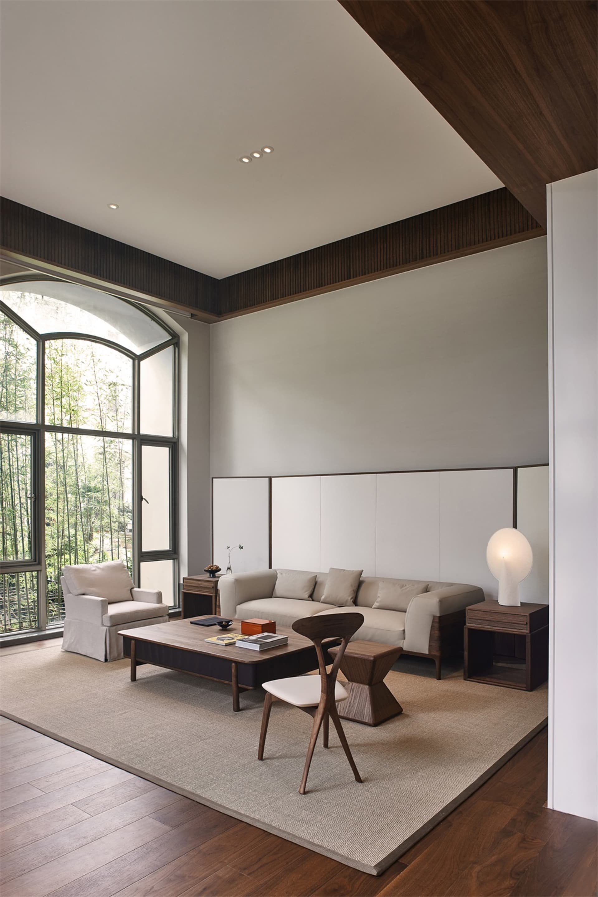 Modern minimalist living room featuring a sofa, armchair, coffee table, and floor lamp.