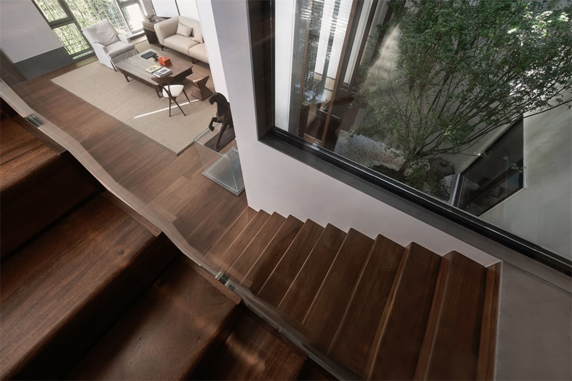 Modern, wooden staircase with glass railings in a contemporary interior design setting.