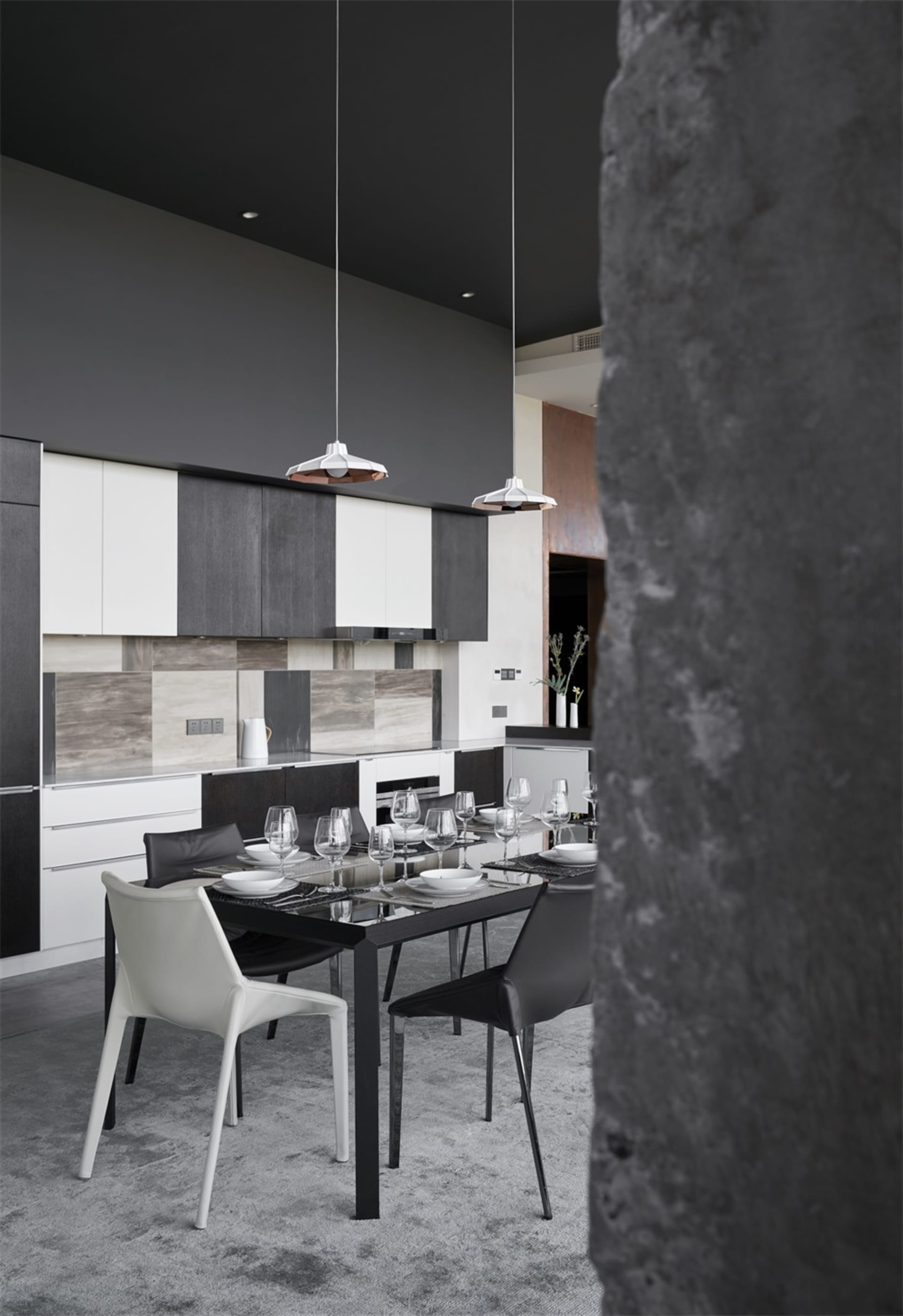 Modern interior design featuring metallic black and white kitchen and dining room with pendant lights and sleek furniture.