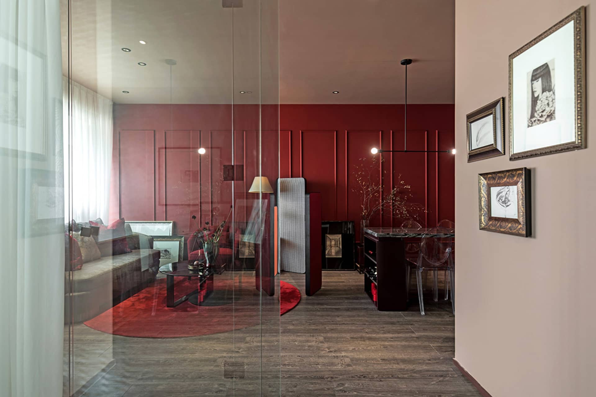 A modern living space with a red accent wall and wooden furnishings.