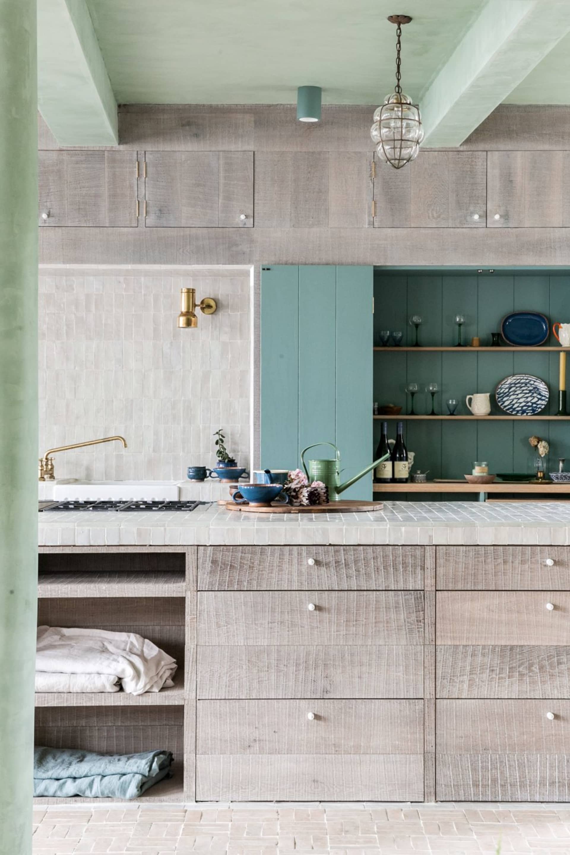A modern kitchen featuring wooden cabinets, white countertops, and glass backsplash.