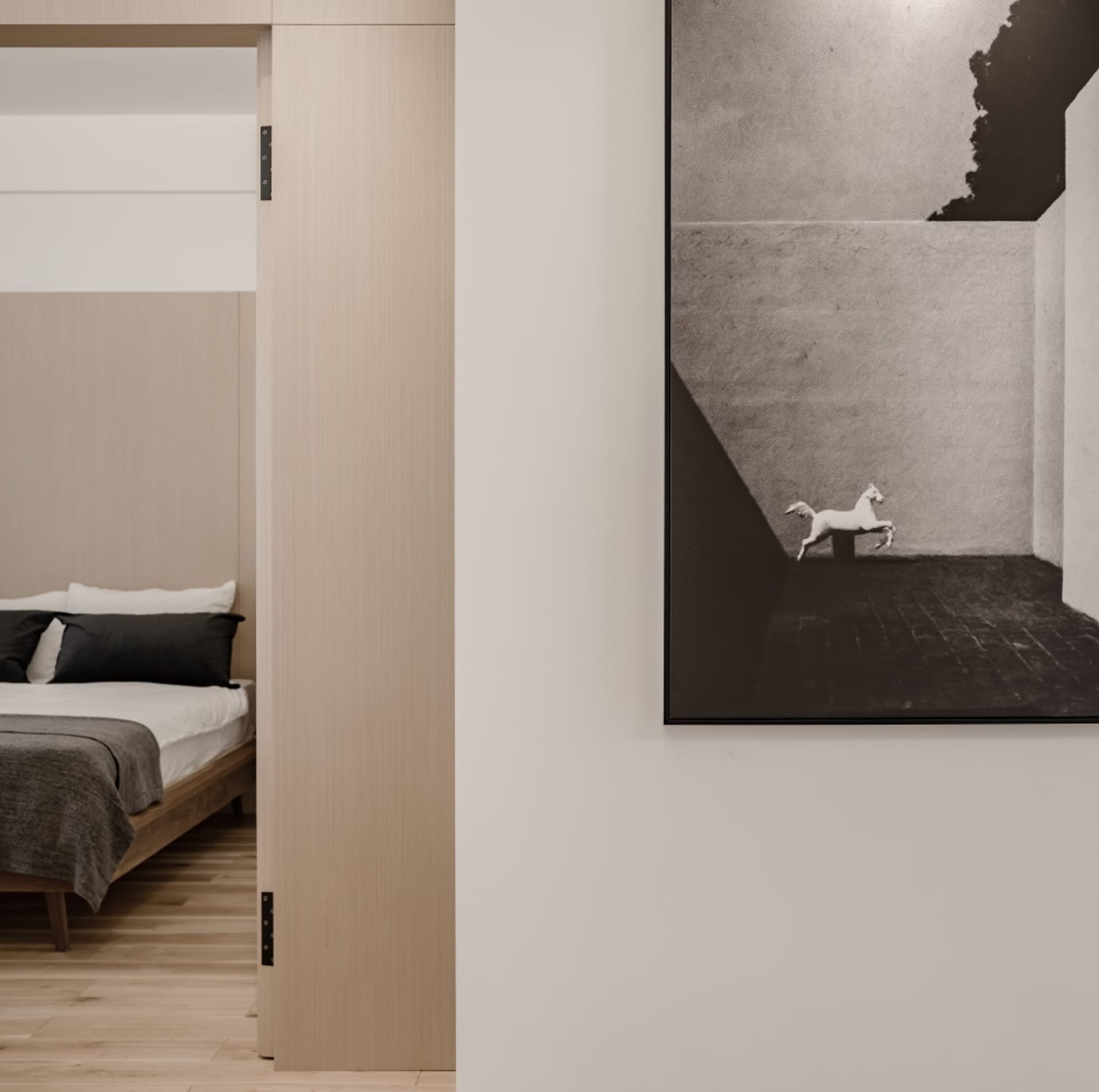 Minimalist bedroom with wood floor, concrete walls, and clean lines.