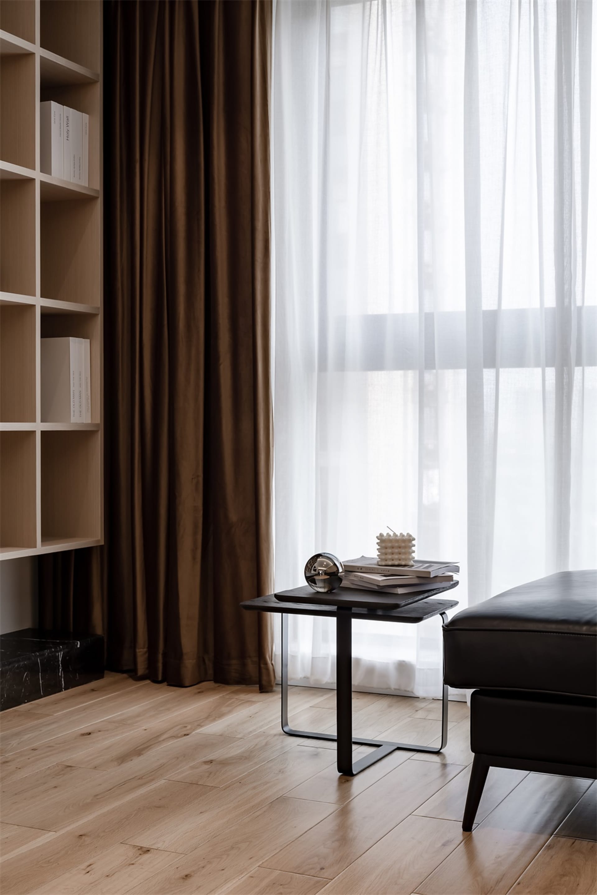 A minimalist living room with a wooden floor, fabric sofa, and simple decor.