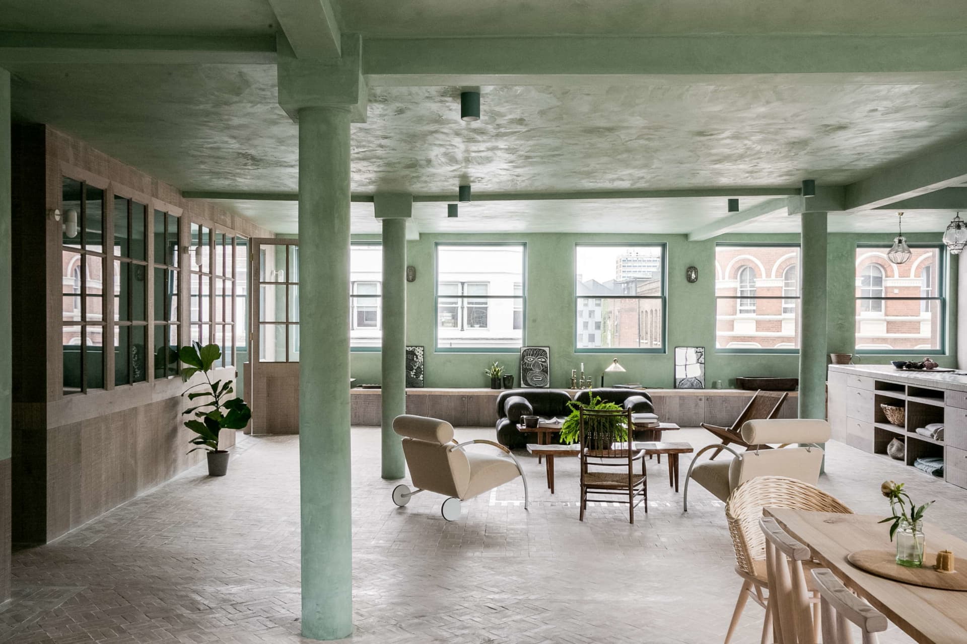 A modern industrial living room with a concrete ceiling, wooden furniture, and glass windows.