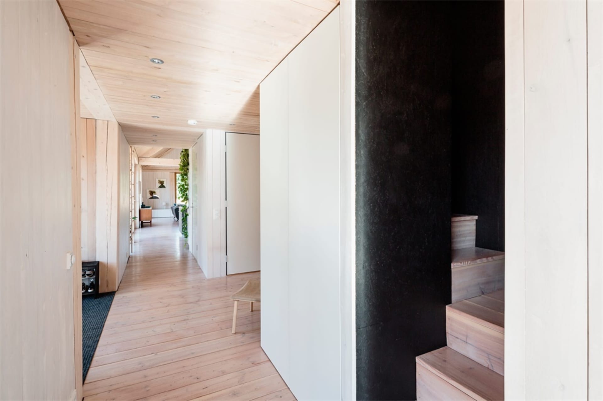 A modern minimalist house interior with wood flooring and white walls.