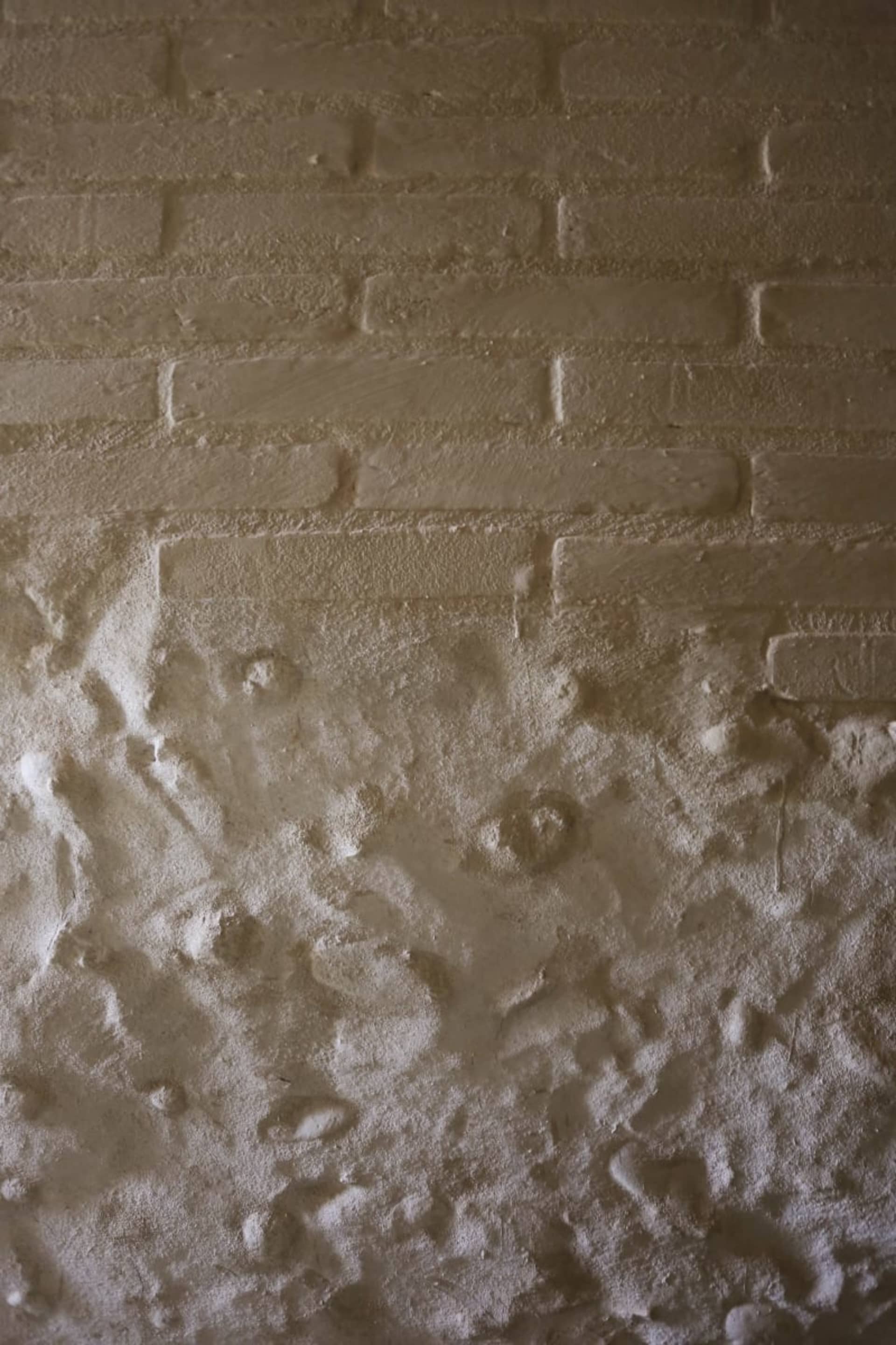 Industrial-style wall featuring a brick pattern painted with a textured finish.