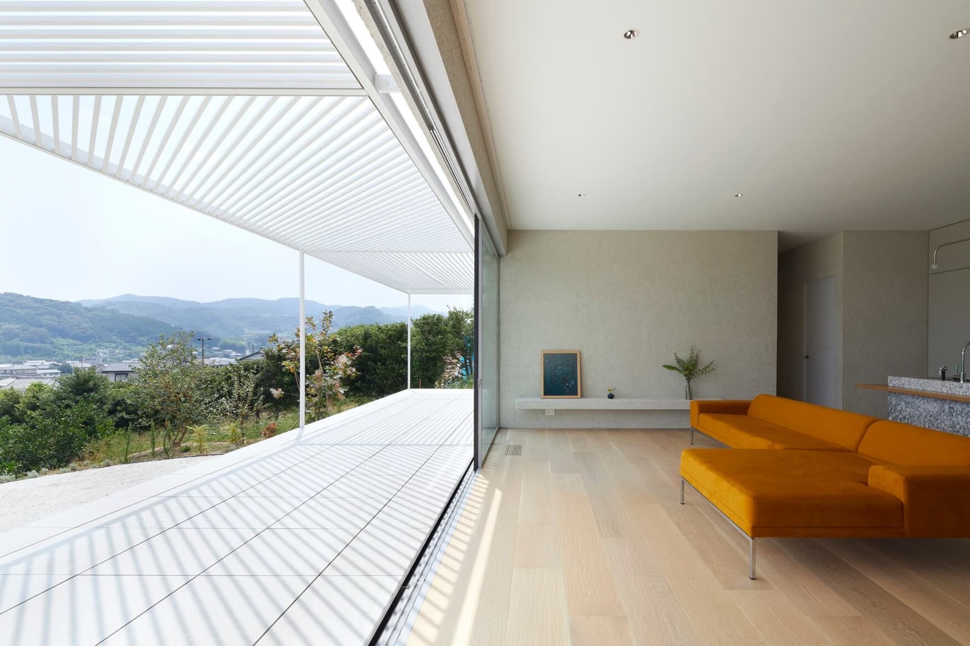 Modern living room featuring a concrete floor and large windows with a view of the mountains.