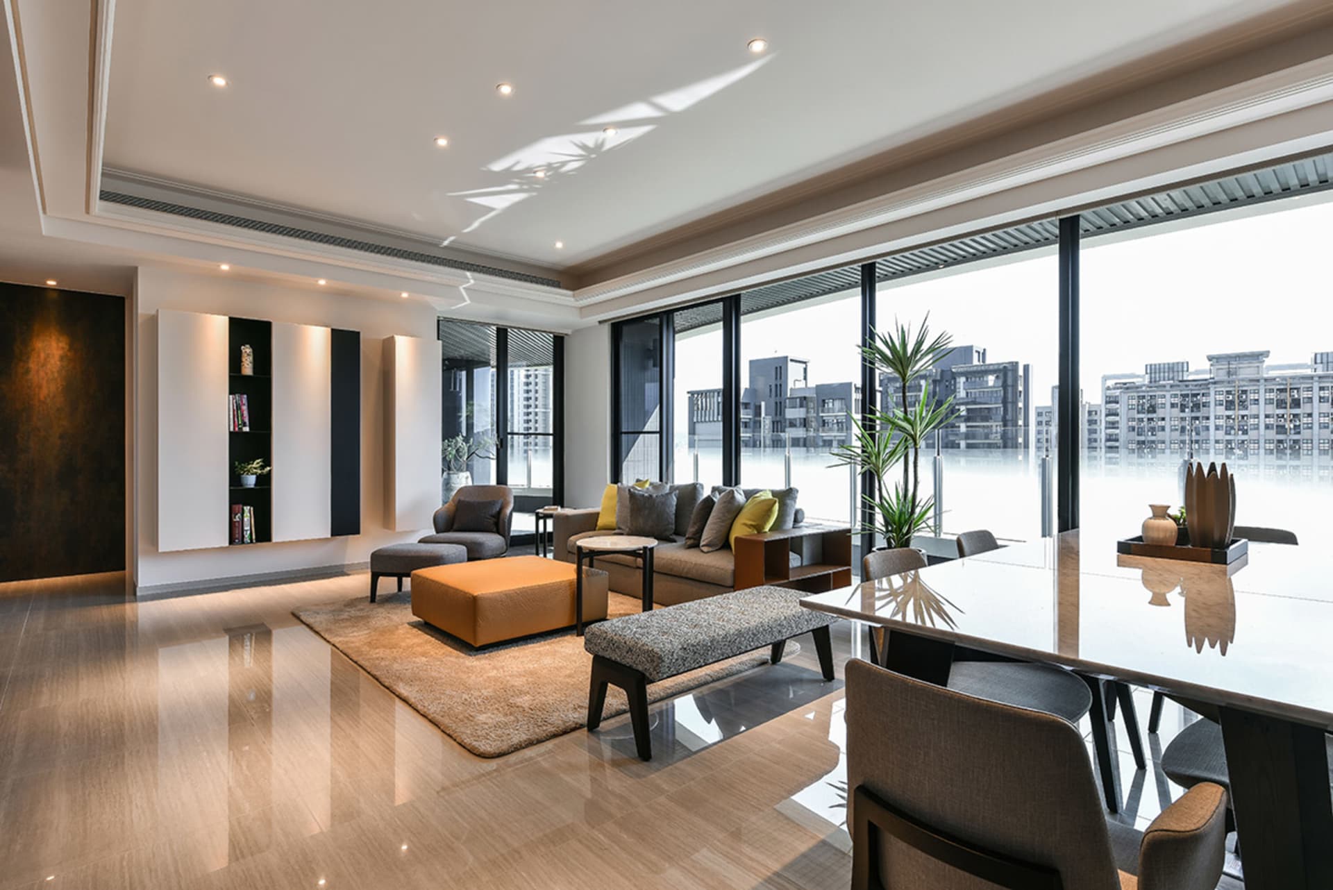 Modern living room featuring glass and leather furniture, large windows, and contemporary decor.