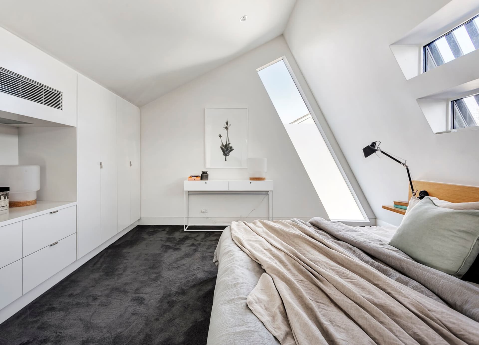 Modern white bedroom with concrete furniture and grey carpet