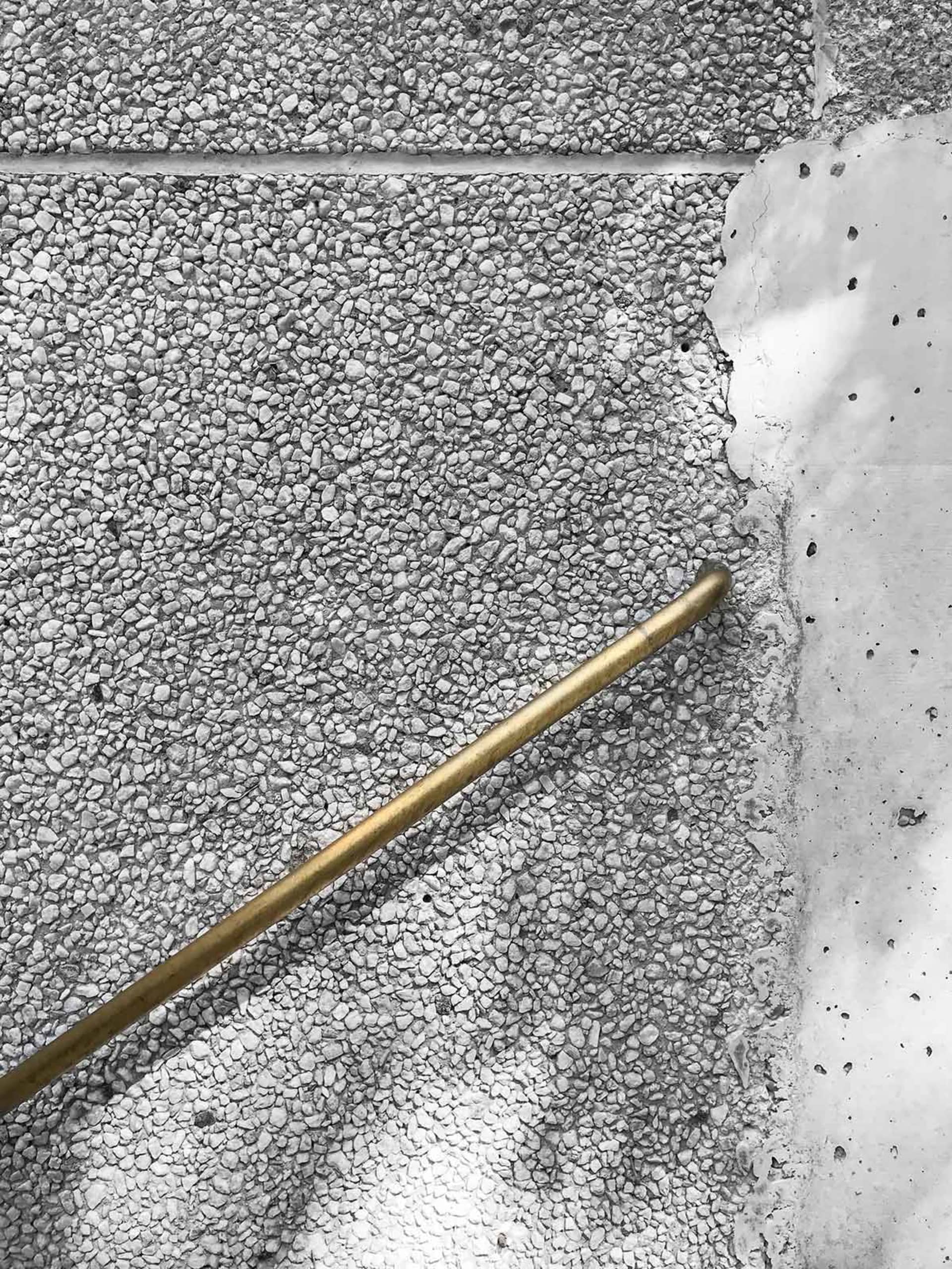 A brass pipe embedded in a concrete floor.