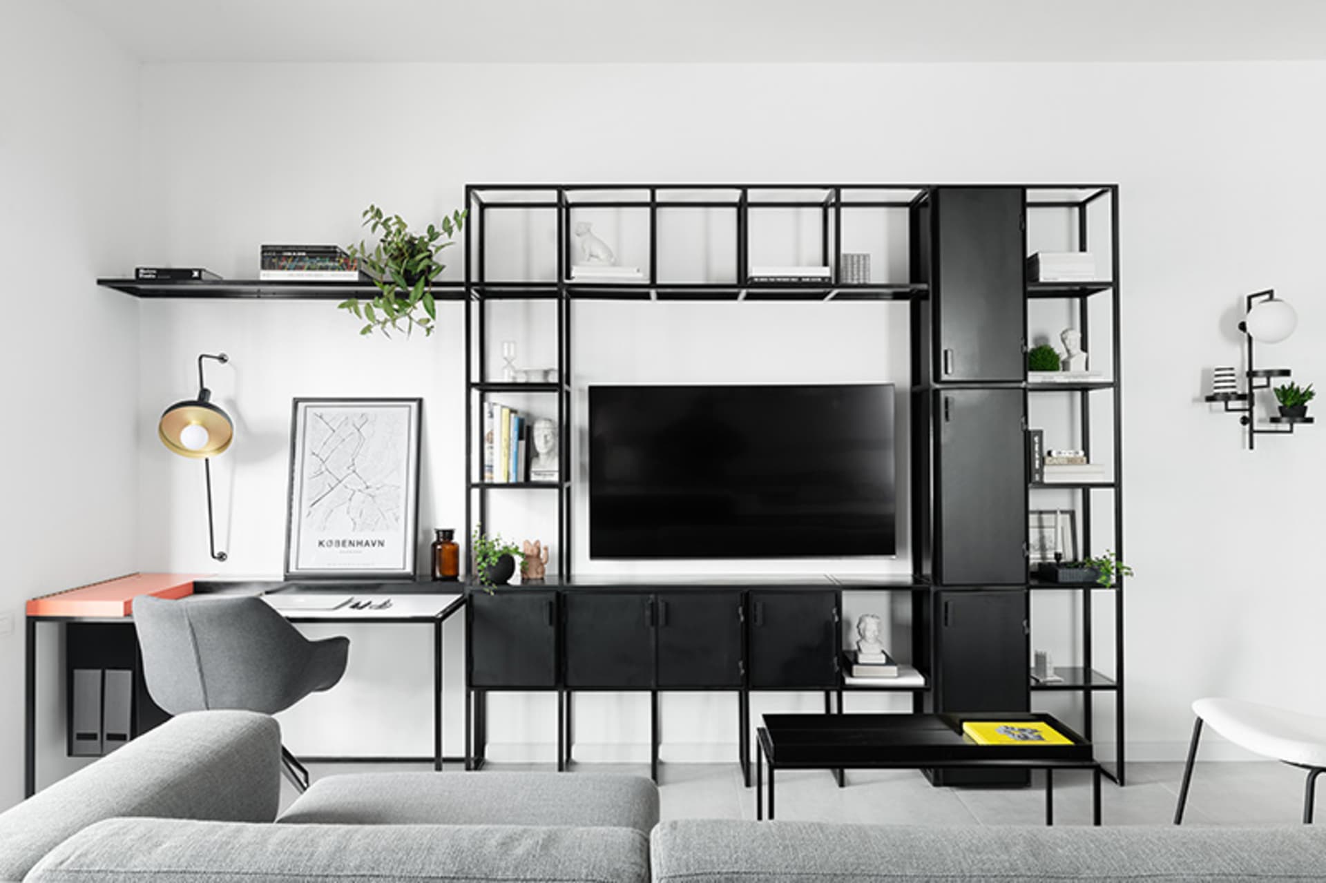 Modern minimalist living room featuring black metal furniture, white walls, and a flat-screen TV.