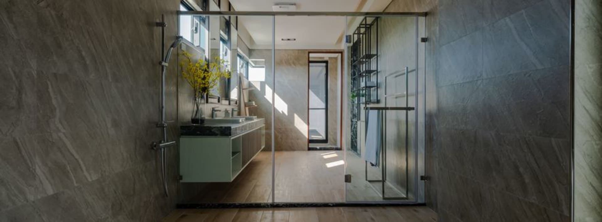 Modern bathroom with marble tiles and glass shower enclosure.