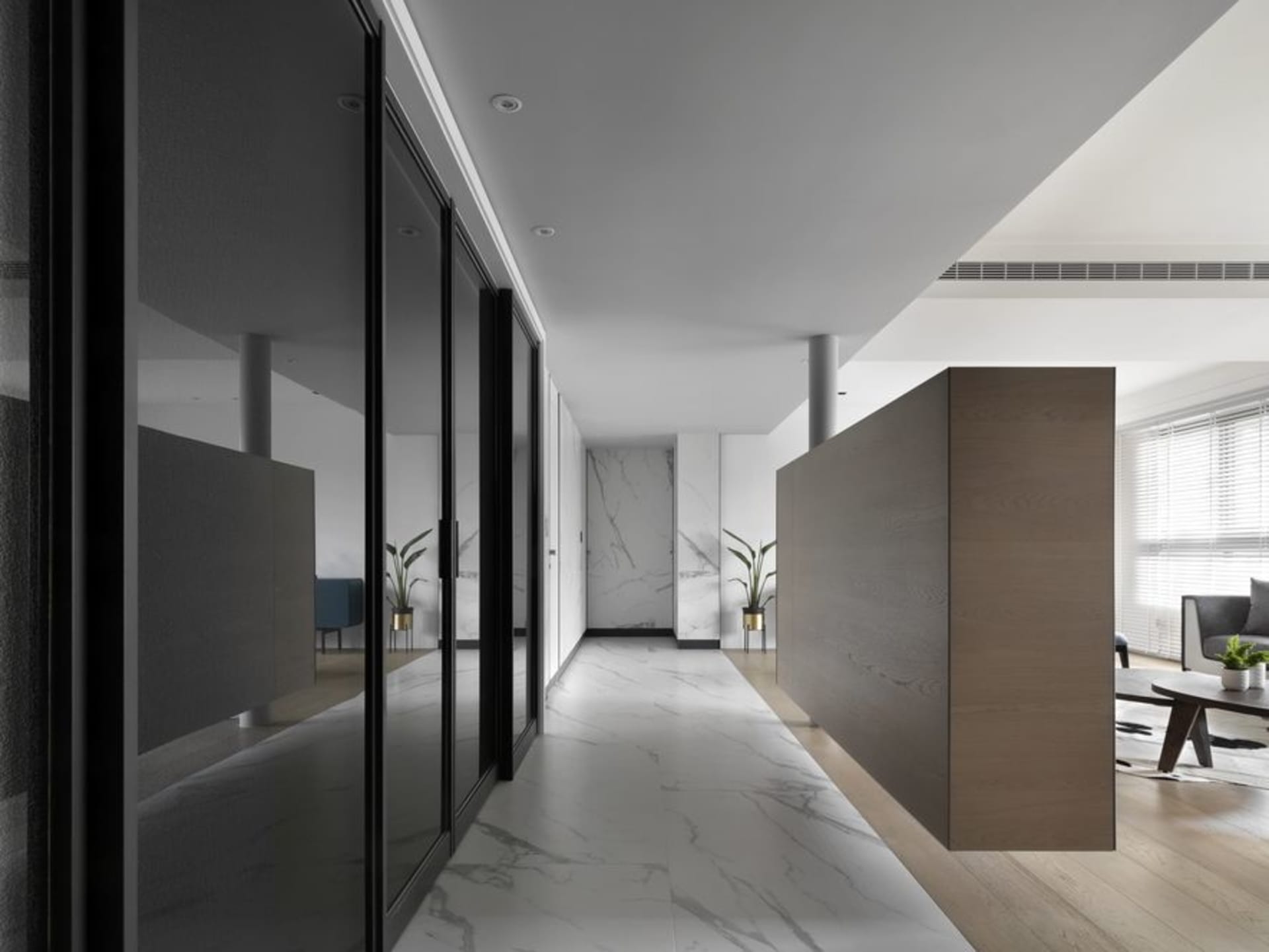 Modern, minimalist corridor featuring marble flooring and glass doors.