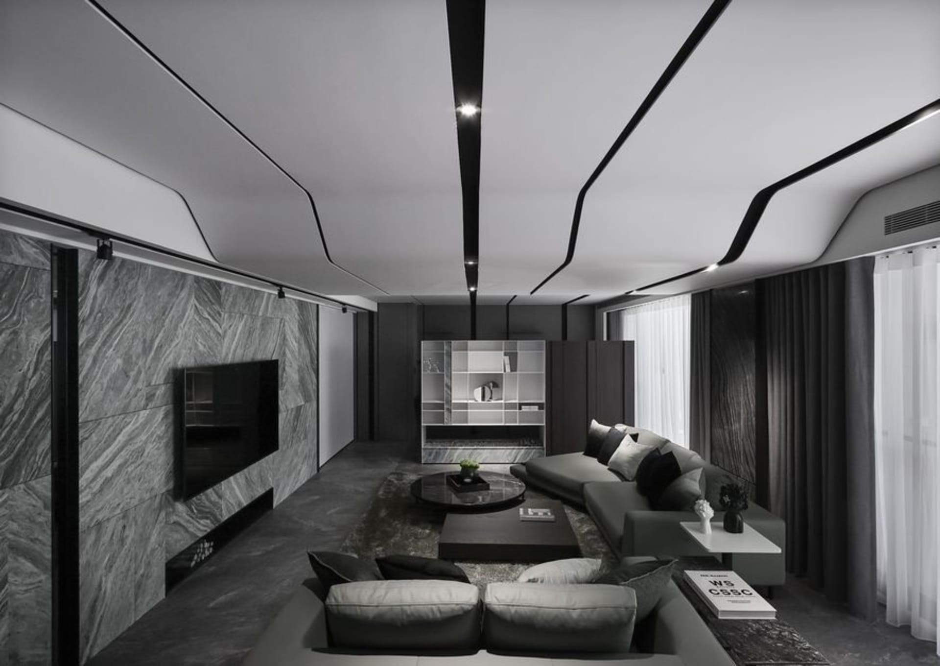 A minimalist living room with marble accent wall, concrete floor, black and white furniture, and a combination of leather and