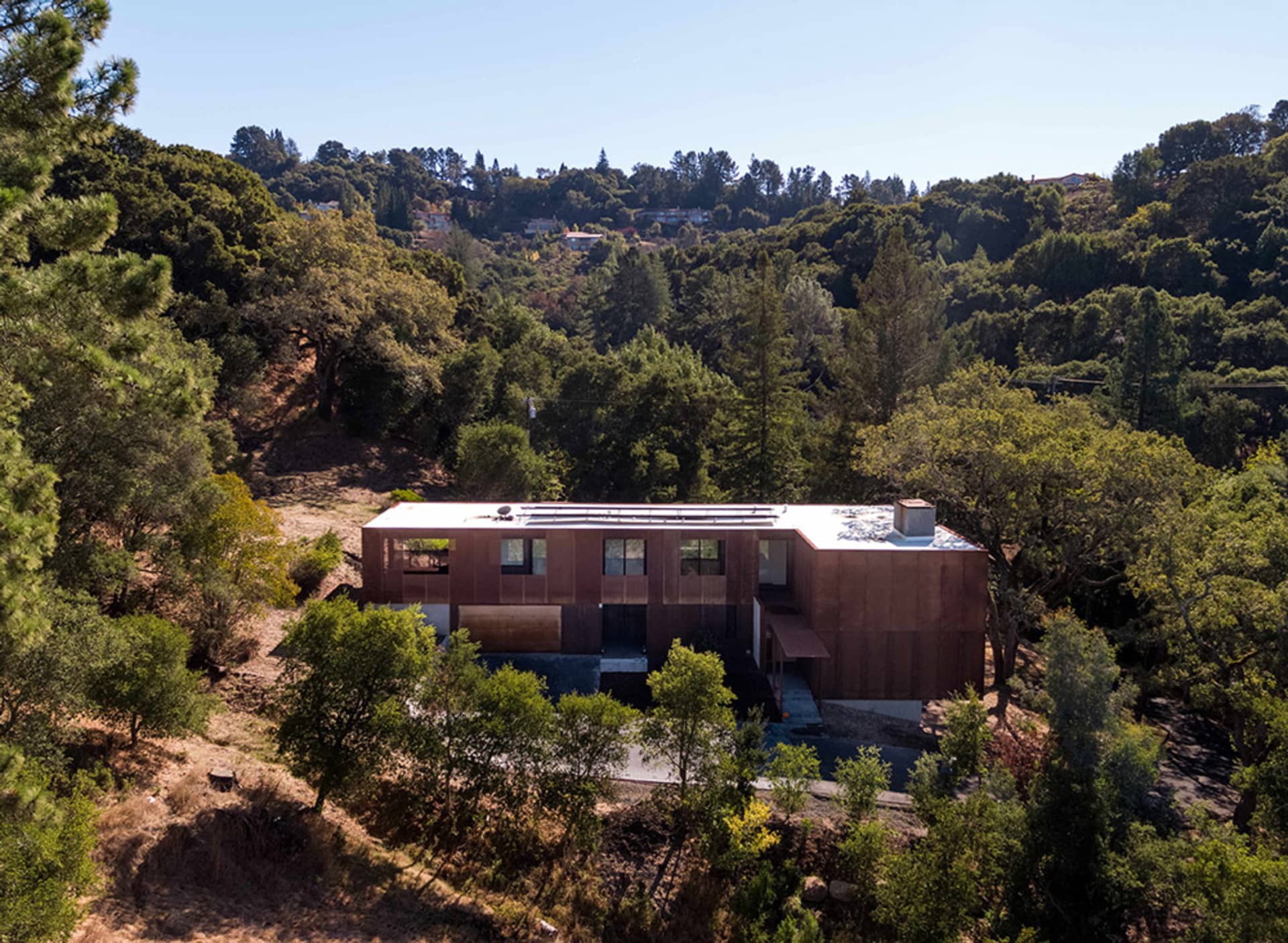 一座現代住宅木造房屋，外牆採用木質建材，周圍環繞樹木。
