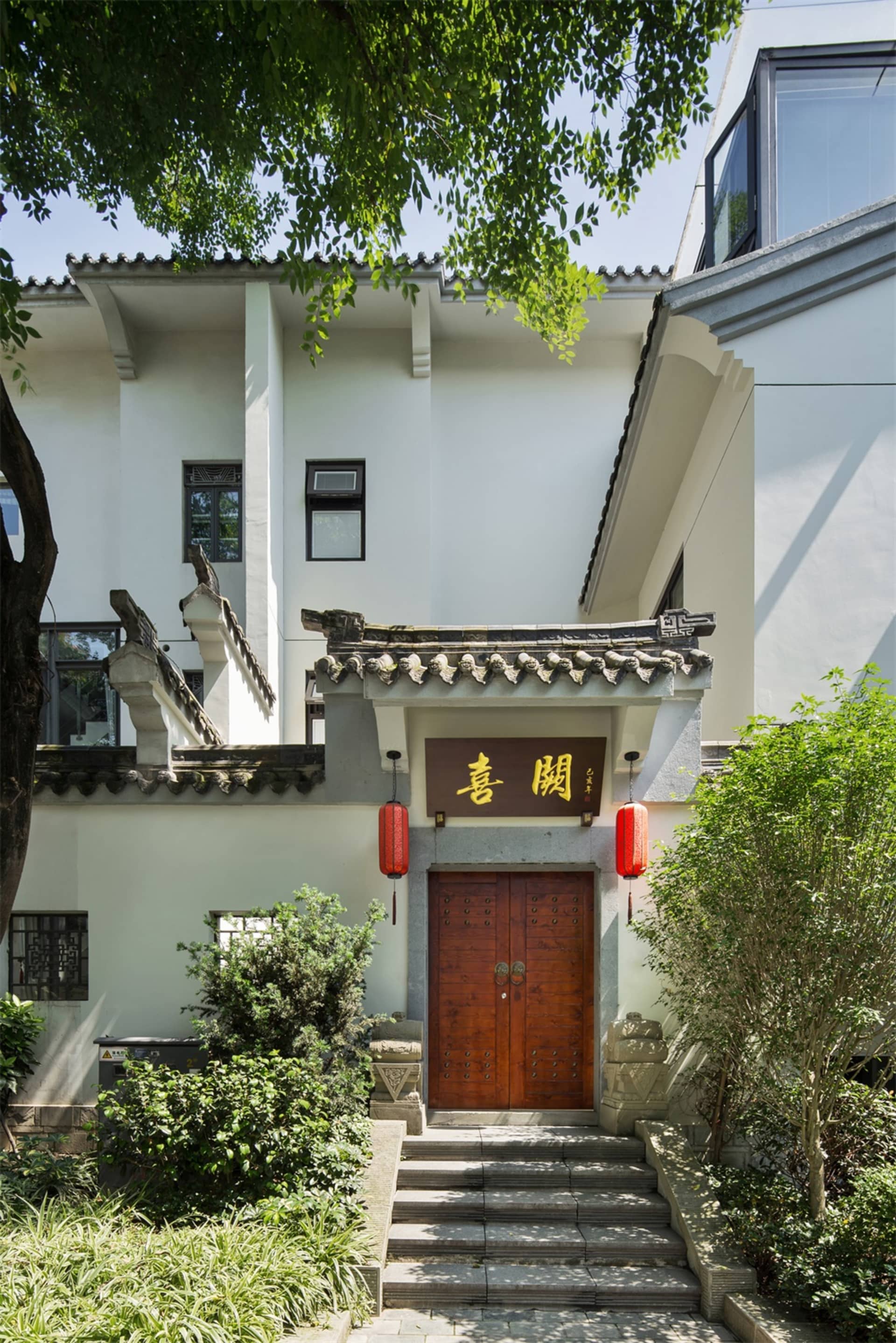 傳統白色住宅玄關,搭配木門與紅燈籠。