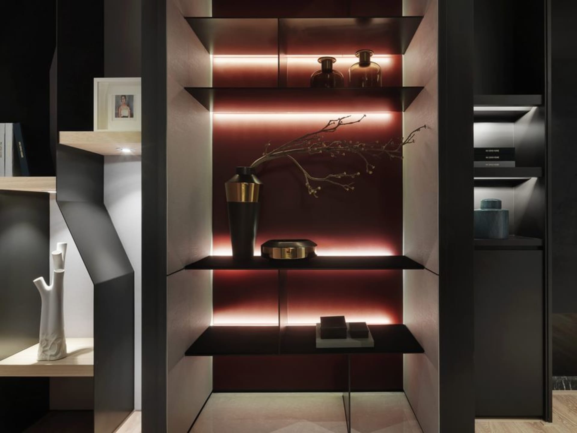 A modern metal shelf with red lighting and decorative branches.