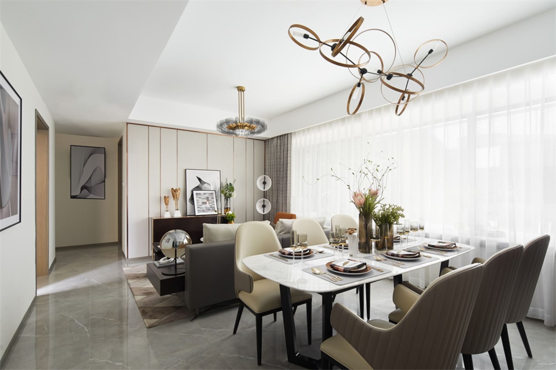 A modern dining room with a large white marble table surrounded by upholstered chairs, adorned with elegant tableware and dec