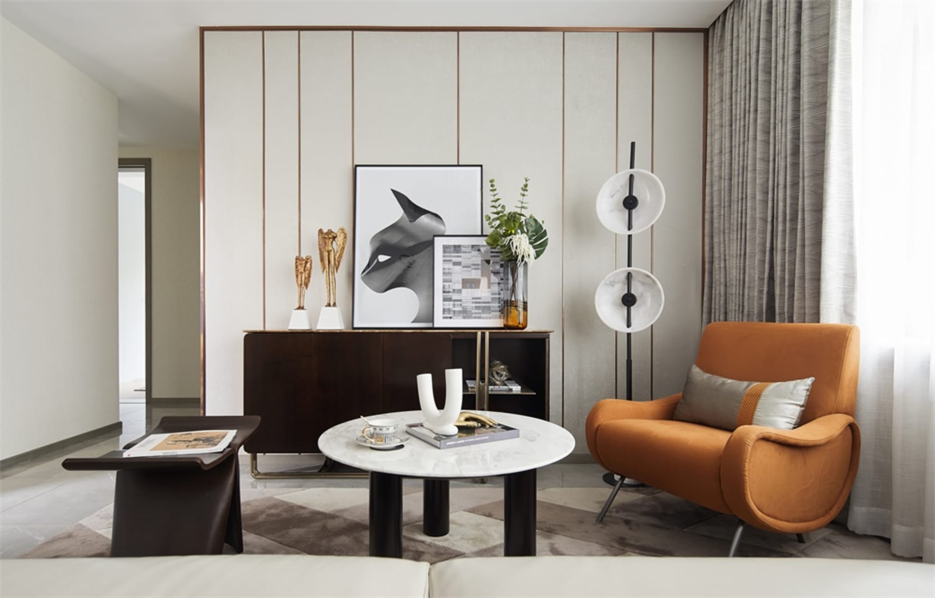 Modern living room with concrete walls, orange armchair, and abstract art.