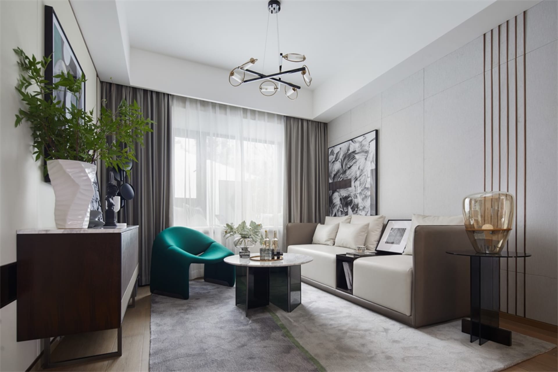 A modern minimalist living room featuring a white couch with white and green pillows, a round coffee table, and a floor-to-ce