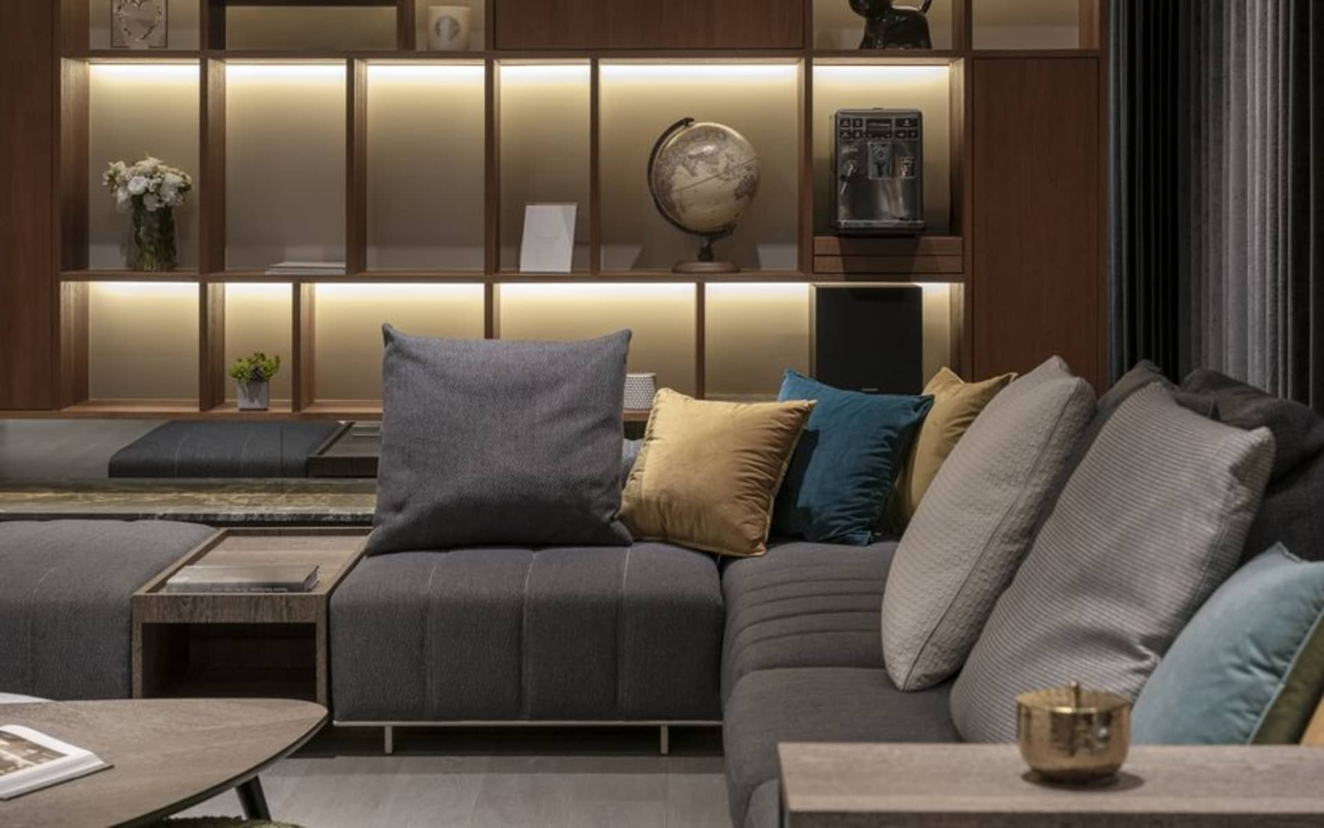 Modern living room with a gray sofa, decorative pillows, and coffee table.