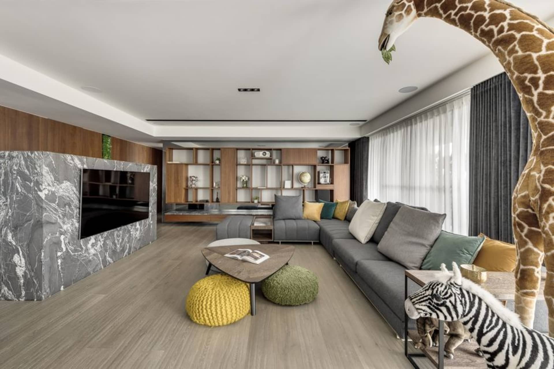 Modern living room featuring wooden floors, marble accents, and metallic elements.