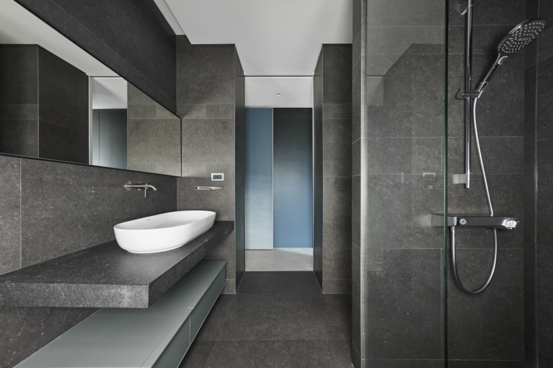 A modern bathroom with a concrete sink and floor.
