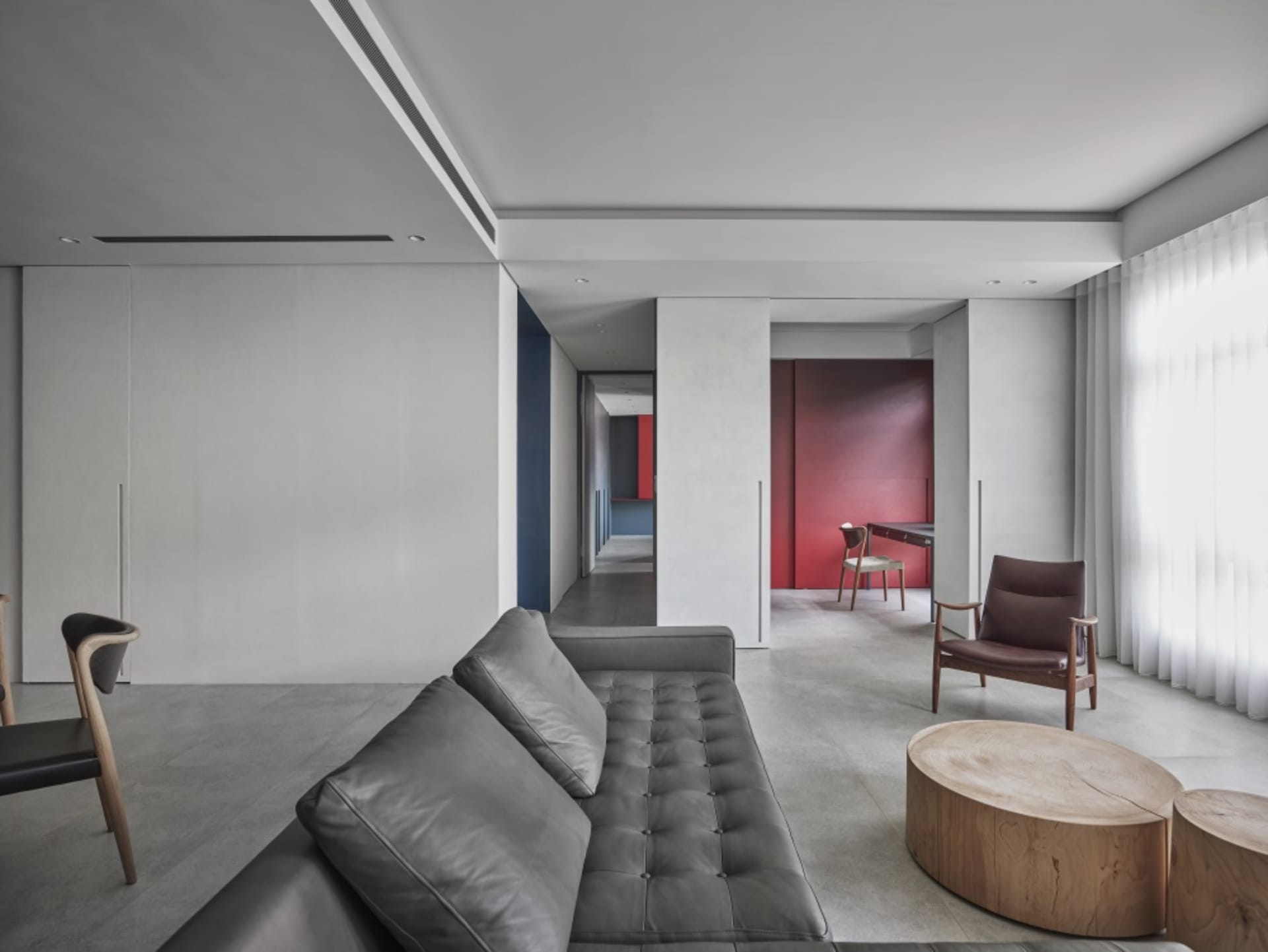A modern living room with a grey leather sofa and wooden coffee table, under a ceiling with recessed lighting.